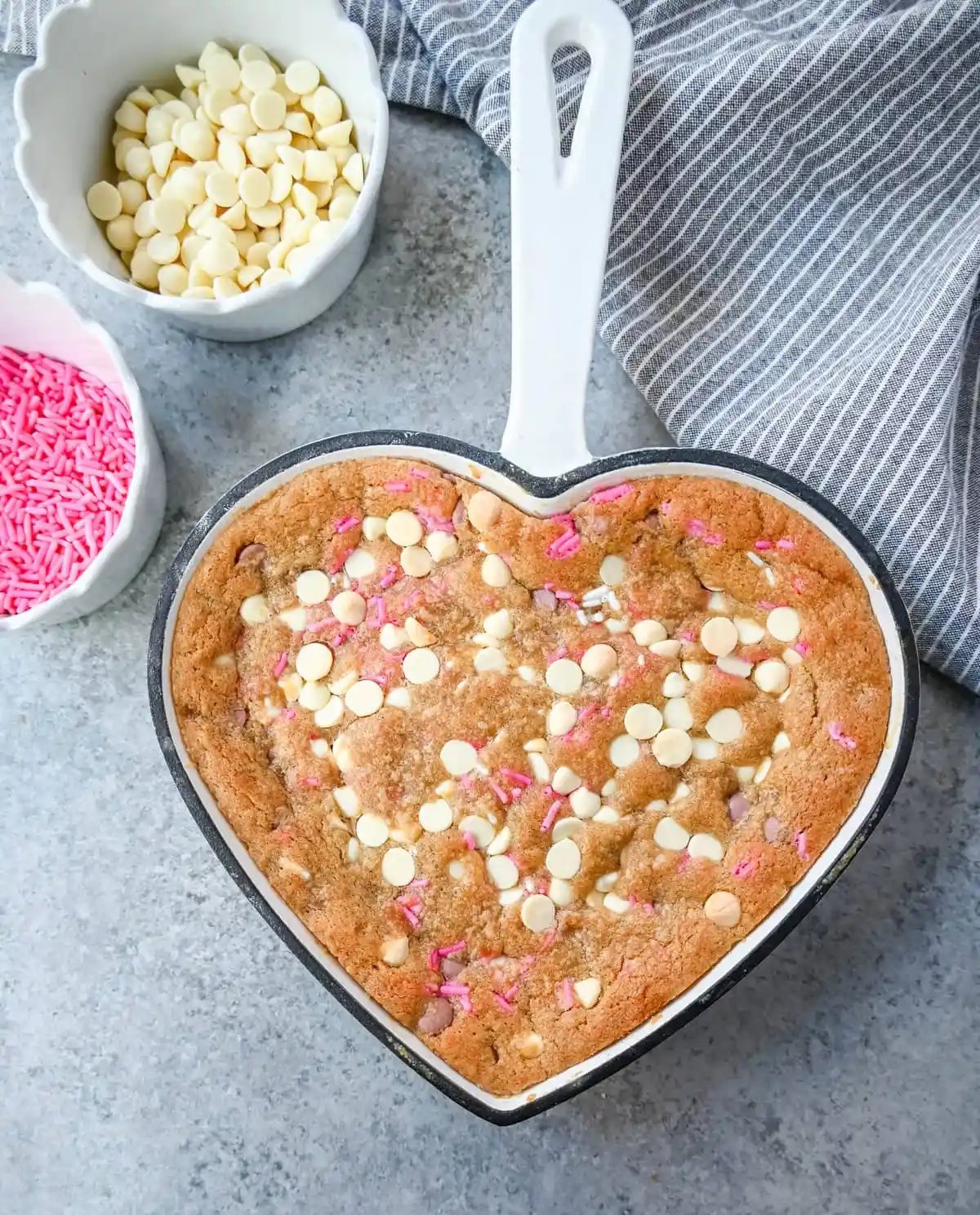 Valentine's Day Heart Skillet Cookie. Soft, chewy skillet cookie recipe filled with white chocolate chips, pink sprinkles, and any of your favorite festive additions such as Valentine's Day M&M's and ruby chocolate. Top it with vanilla ice cream and have the perfect Valentine's Day dessert.