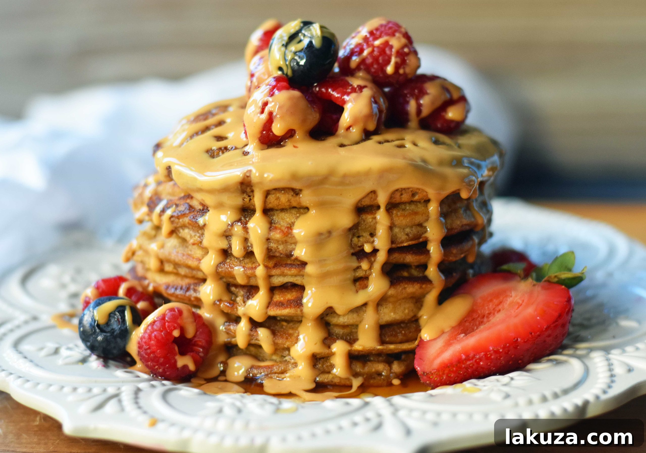 Protein Power Pancakes 5 Close-up of fluffy protein pancakes with collagen, drizzled with maple syrup and fresh blueberries.