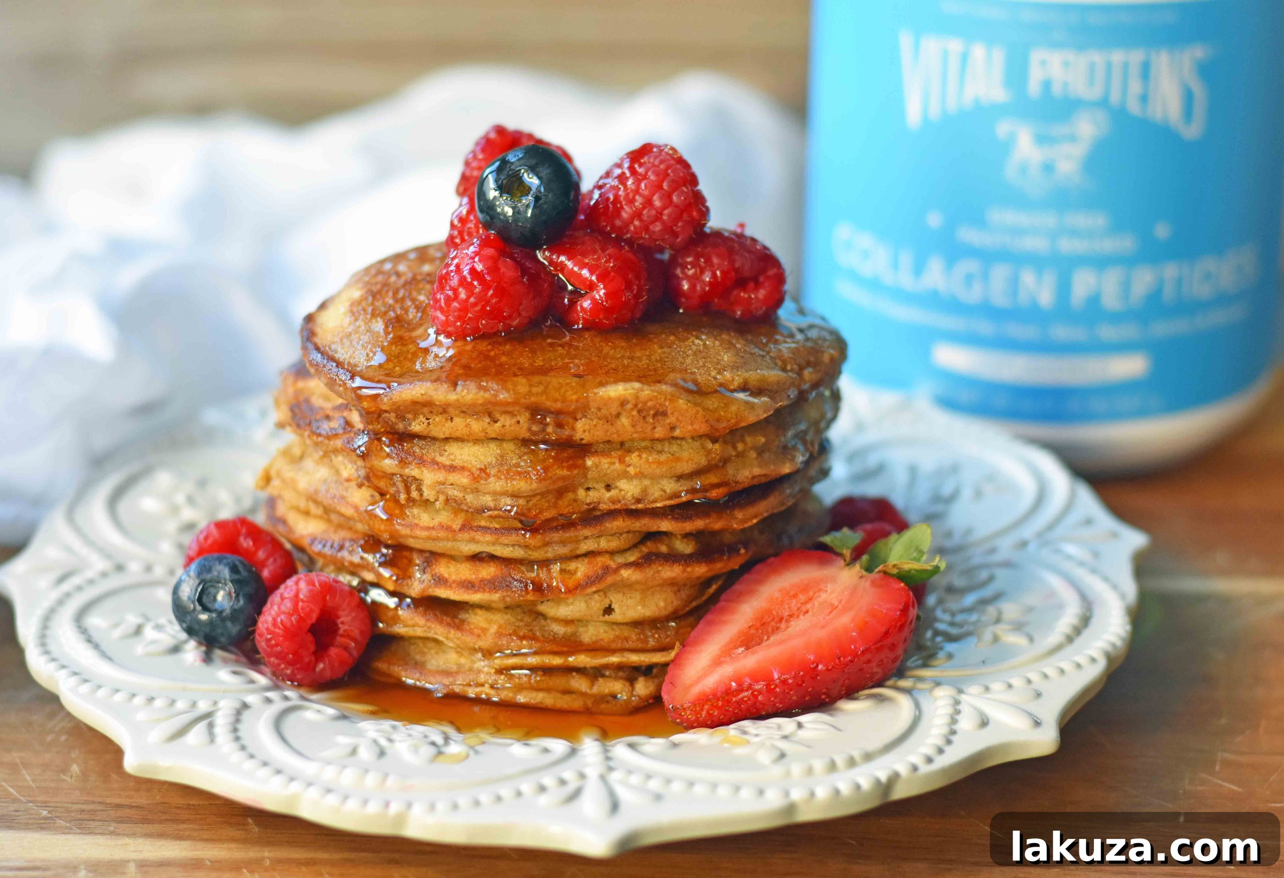 Protein Power Pancakes 6 A serving of healthy protein pancakes with collagen, topped with fresh berries, a pat of butter, and maple syrup.