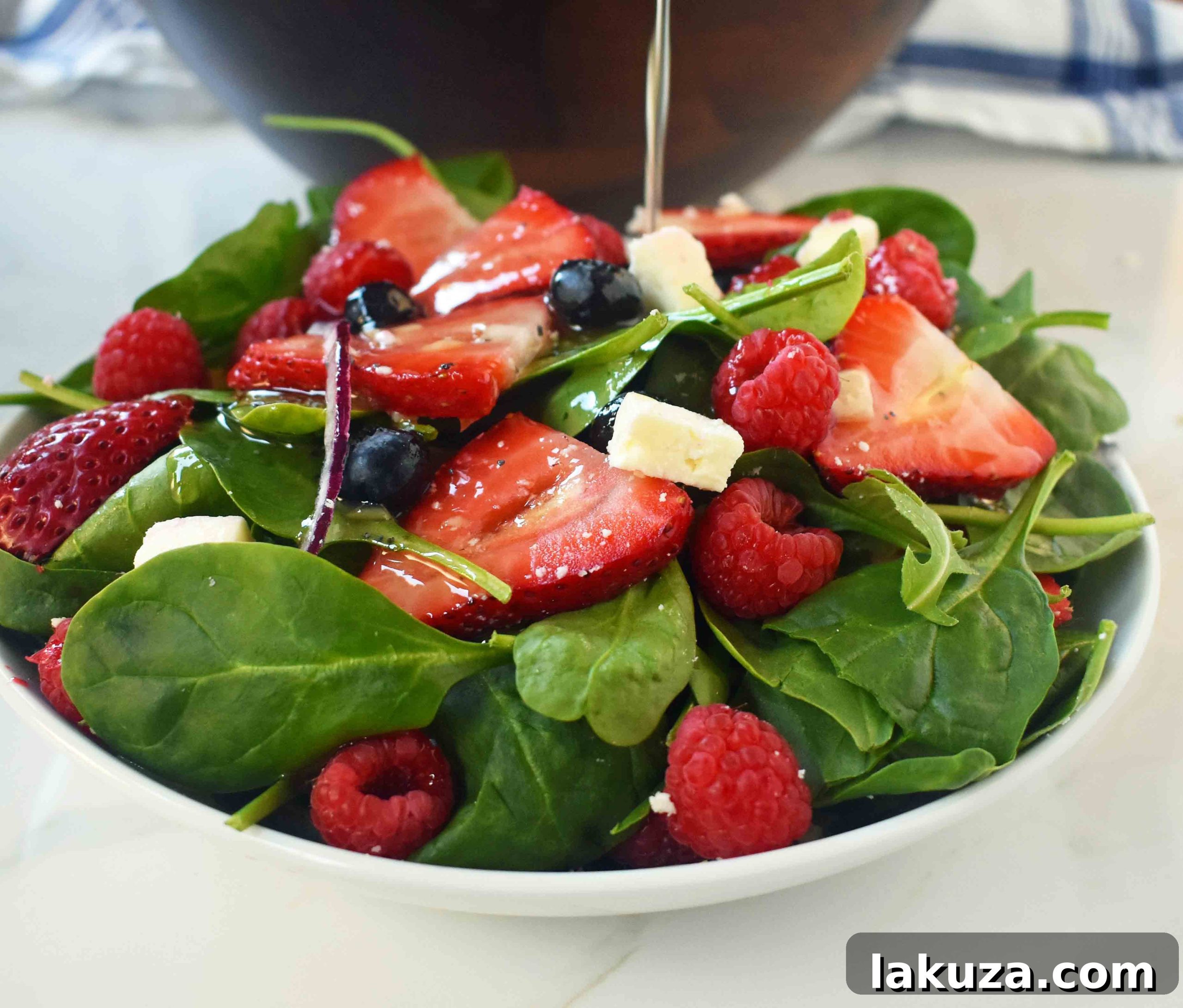 Sweet Poppy Seed Dressed Spinach Berry Salad 4 Spinach Berry Salad with Sweet Poppyseed Dressing. Fresh Spinach Salad with Berries, Feta Cheese, and Poppy Seed Dressing. Ingredients arranged in a bowl.