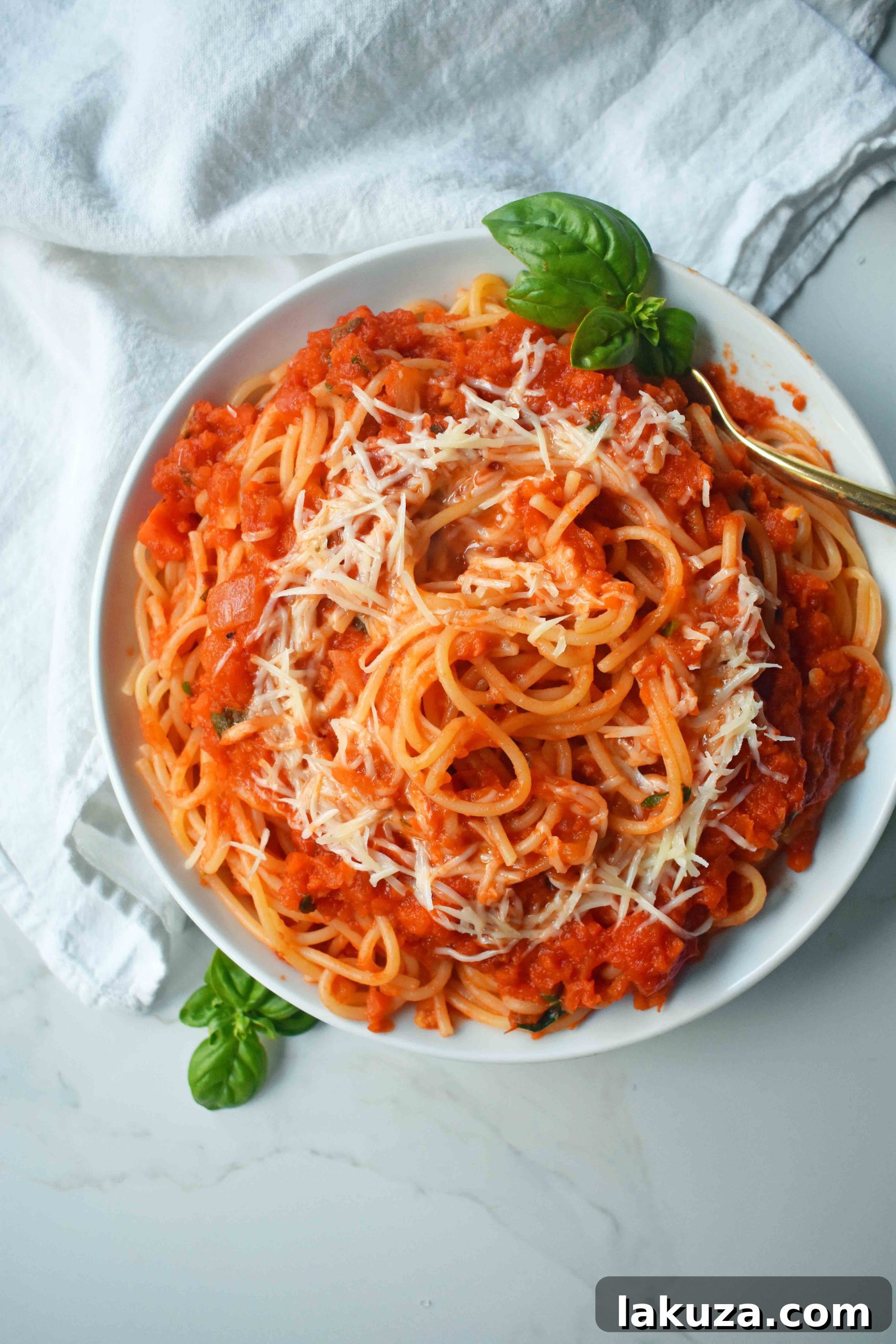 Slow-Simmered Family Marinara 2 A bowl of spaghetti topped with rich, homemade marinara sauce and fresh basil. A classic Italian comfort food.