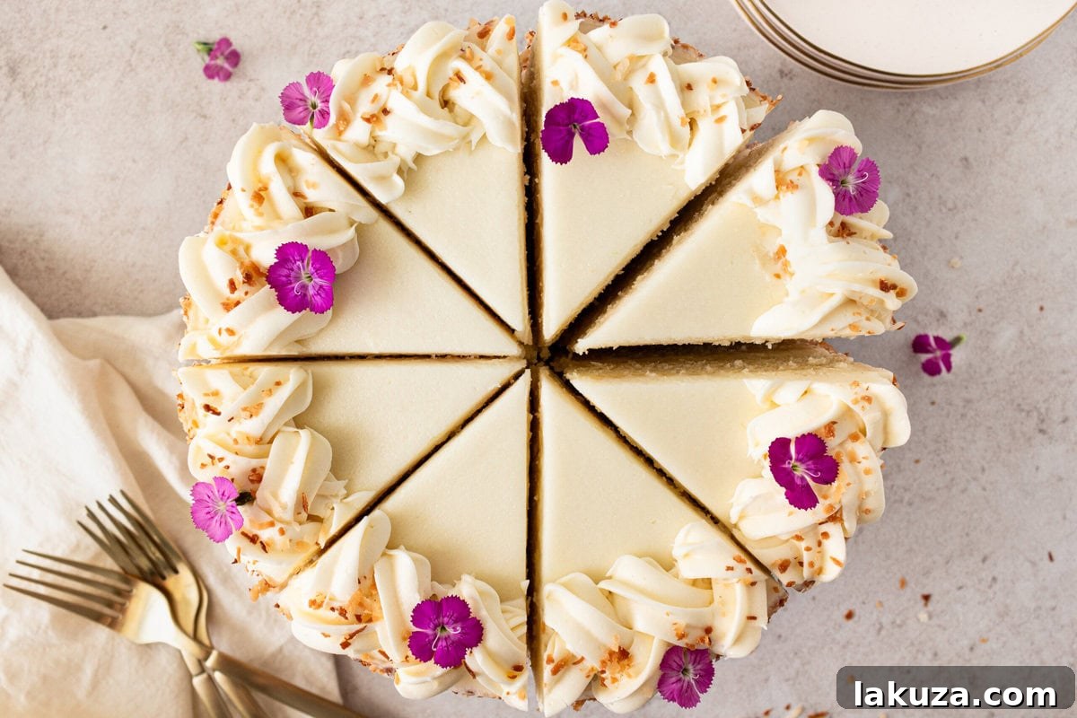 A stunning, fully frosted and decorated homemade coconut cake, adorned with fluffy shredded coconut. This layered cake features a moist crumb and rich cream cheese frosting.