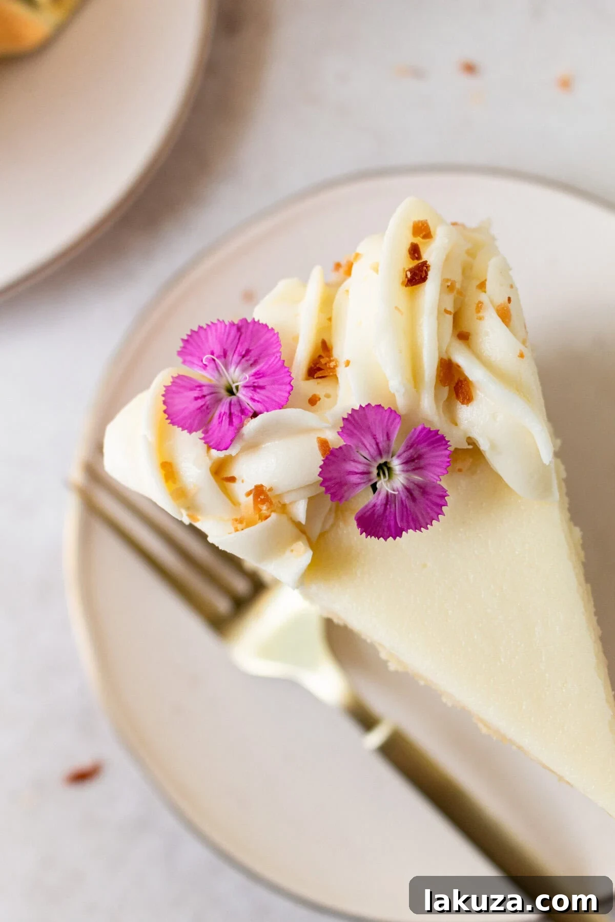 A close-up of the delicate texture and snowy appearance of a homemade coconut cake, frosted and garnished with ample shredded coconut. This best coconut cake recipe offers supreme moisture and flavor.