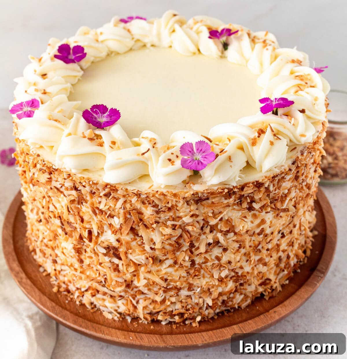 A stunning, multi-layered homemade coconut cake featuring moist cake, rich coconut cream cheese frosting, and shredded coconut garnish. This is the best coconut layer cake recipe.