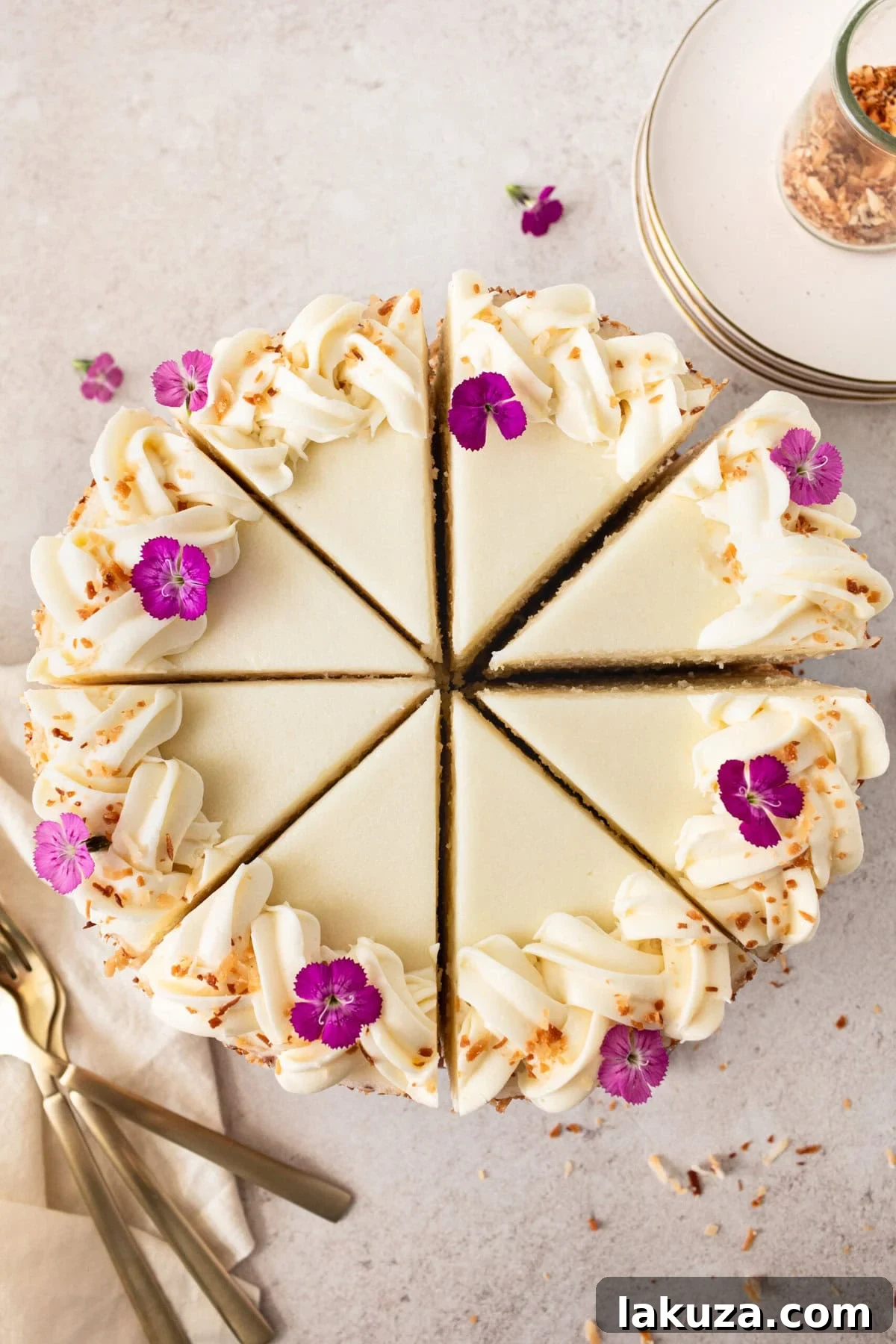 Close-up of a slice of moist coconut cake, showcasing its tender layers and creamy coconut cream cheese frosting. The cake is known for its incredible texture and deep coconut flavor.