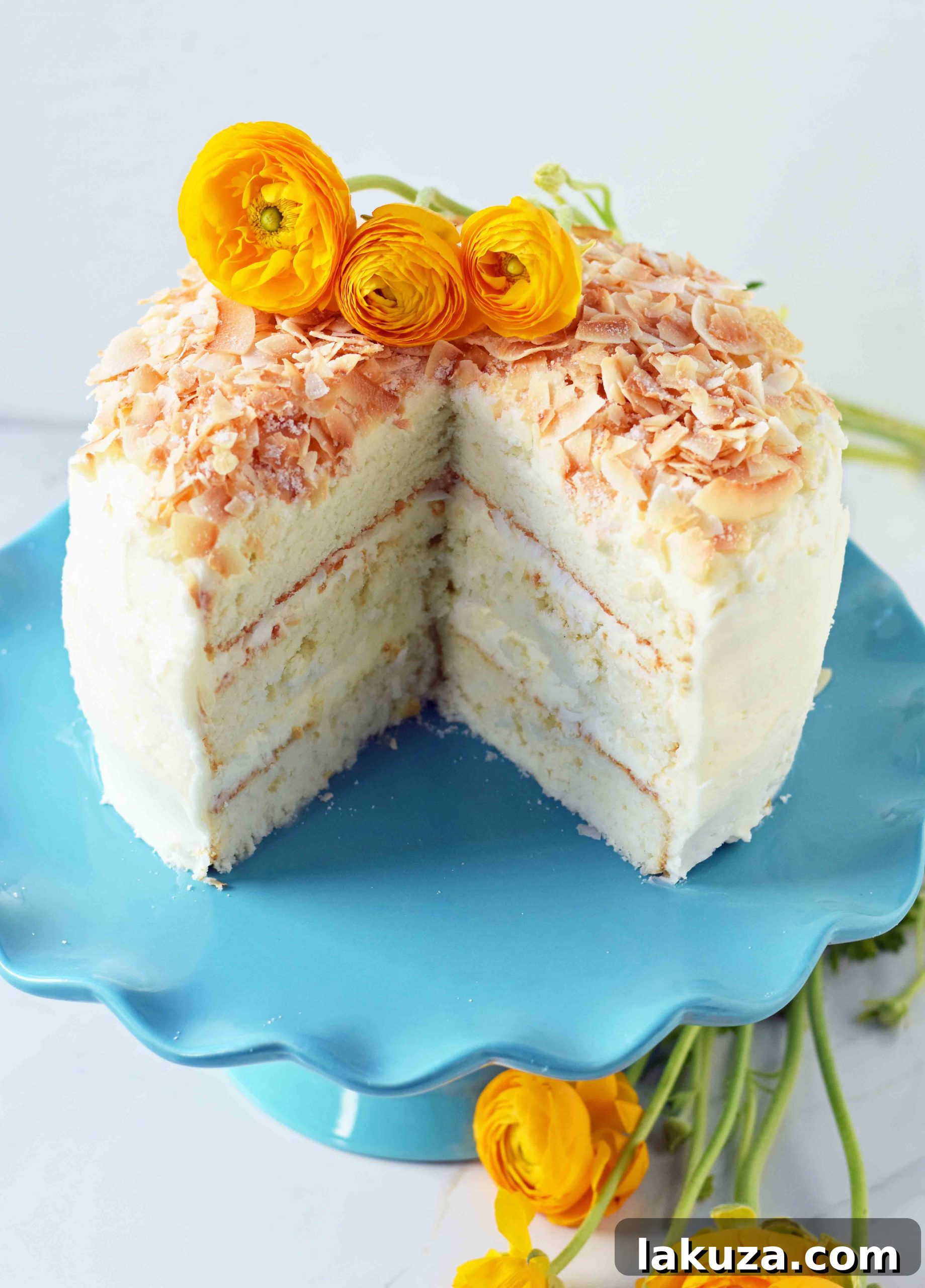 An overhead shot of a delightful slice of coconut cake on a plate, revealing the tender crumb and thick layer of coconut cream cheese frosting. This homemade recipe guarantees the best moist coconut cake.