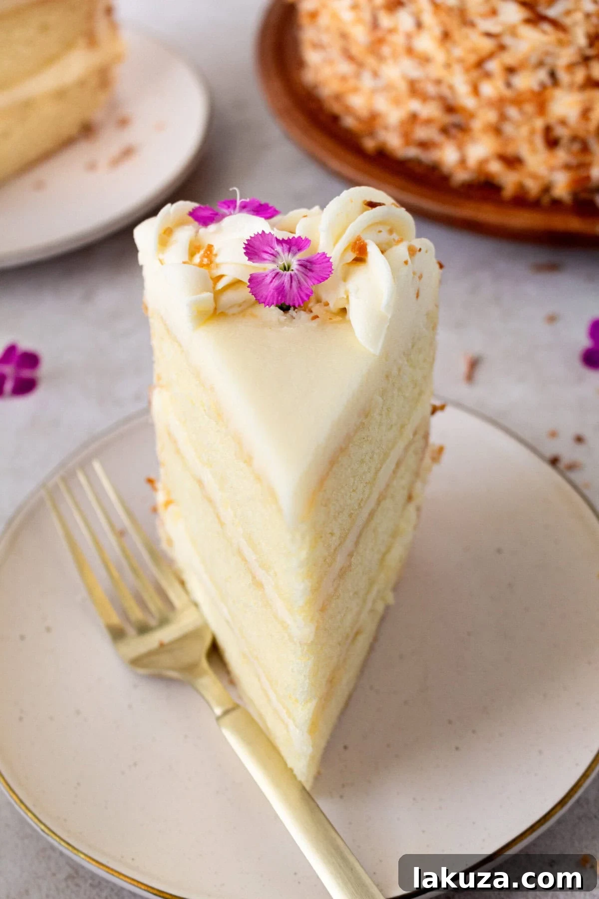 A top-down view of a beautifully frosted homemade coconut cake, adorned with toasted coconut flakes. This layered cake is incredibly moist and topped with a decadent cream cheese frosting.