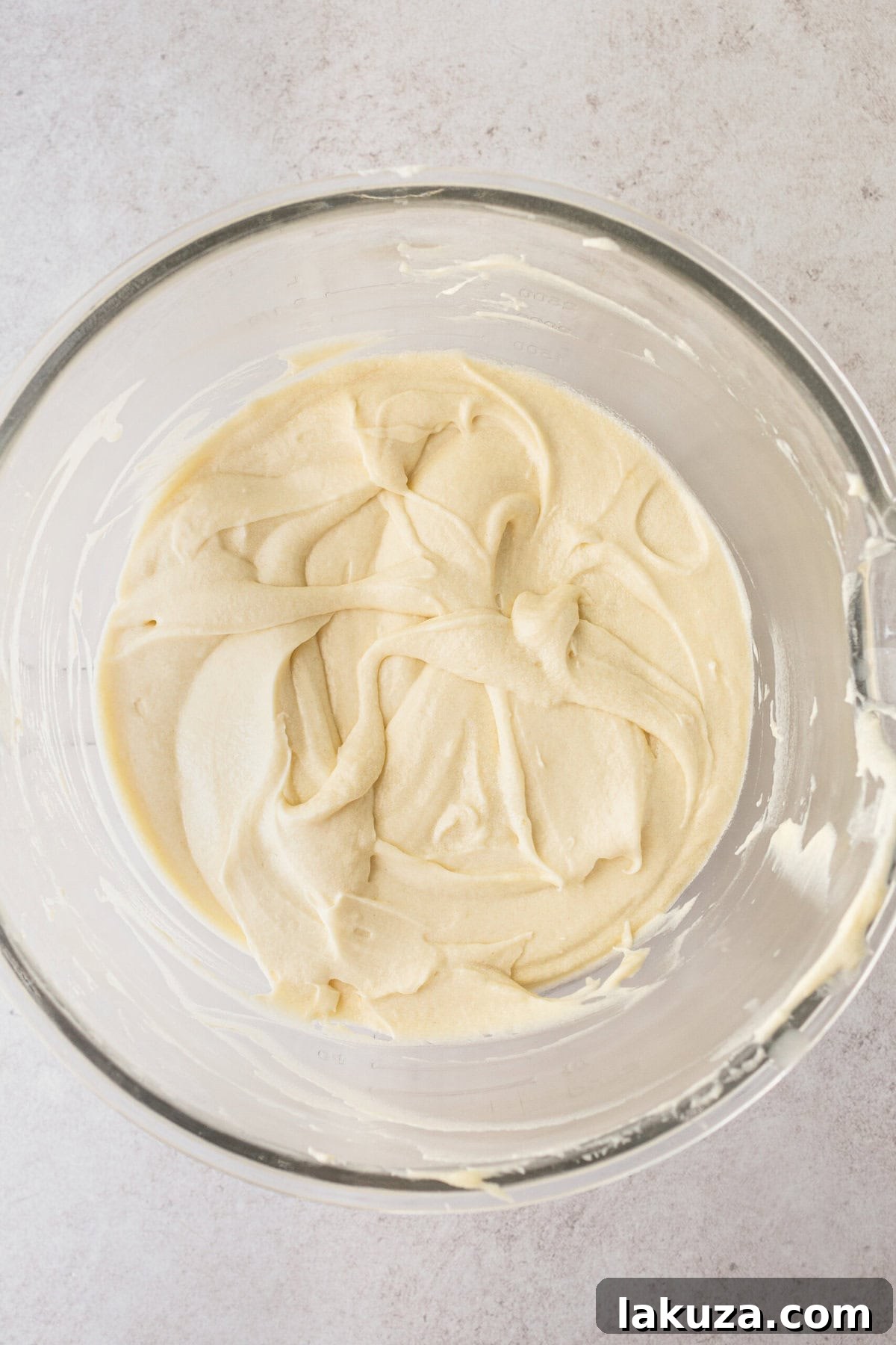Smooth, light, and fluffy homemade coconut cake batter in a mixing bowl, ready to be poured into pans for baking.