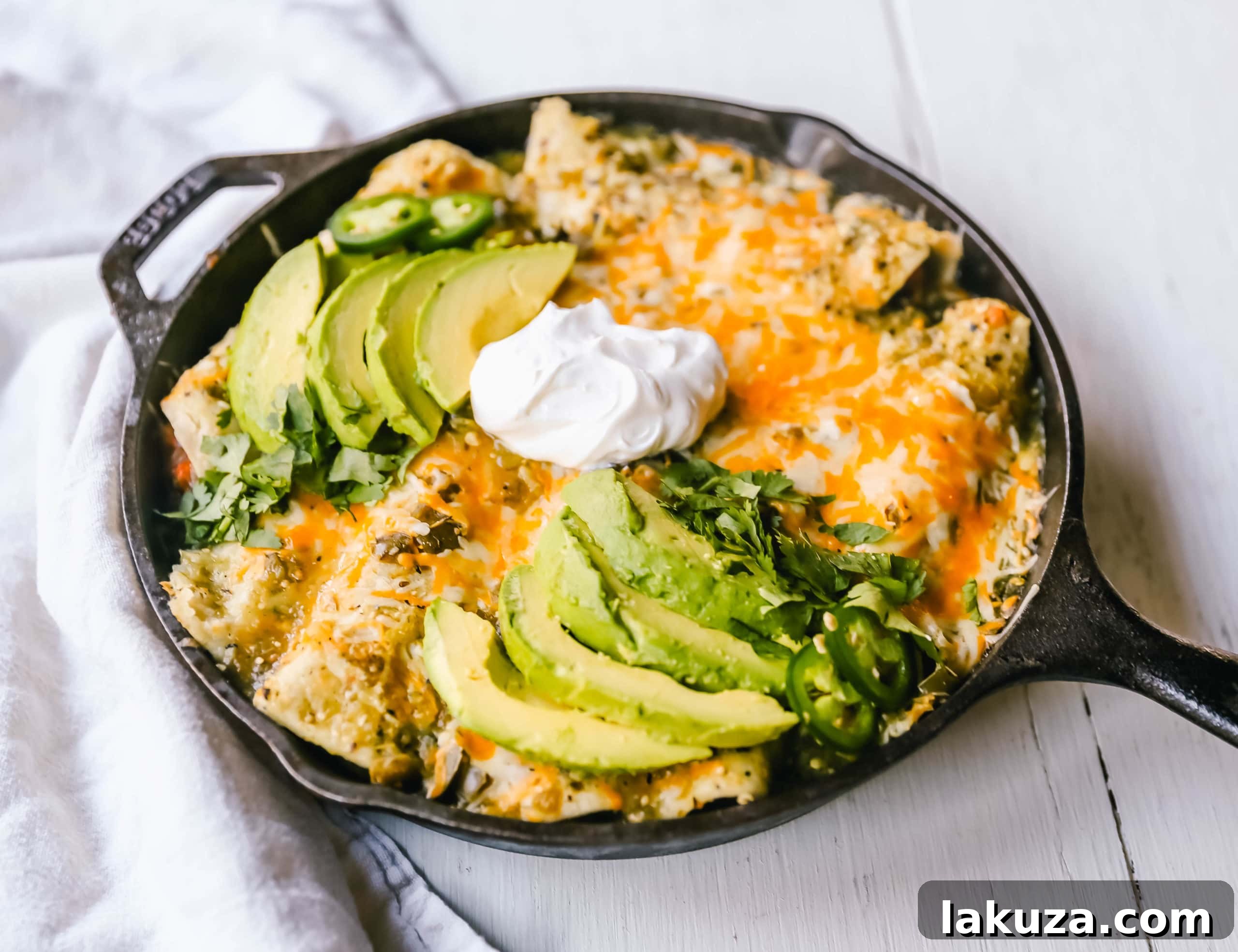 Zesty Sweet Potato and Black Bean Enchiladas 3 Close-up shot of baked Sweet Potato Black Bean Enchiladas, covered in bubbly melted cheese and green salsa, showcasing their mouth-watering appeal.
