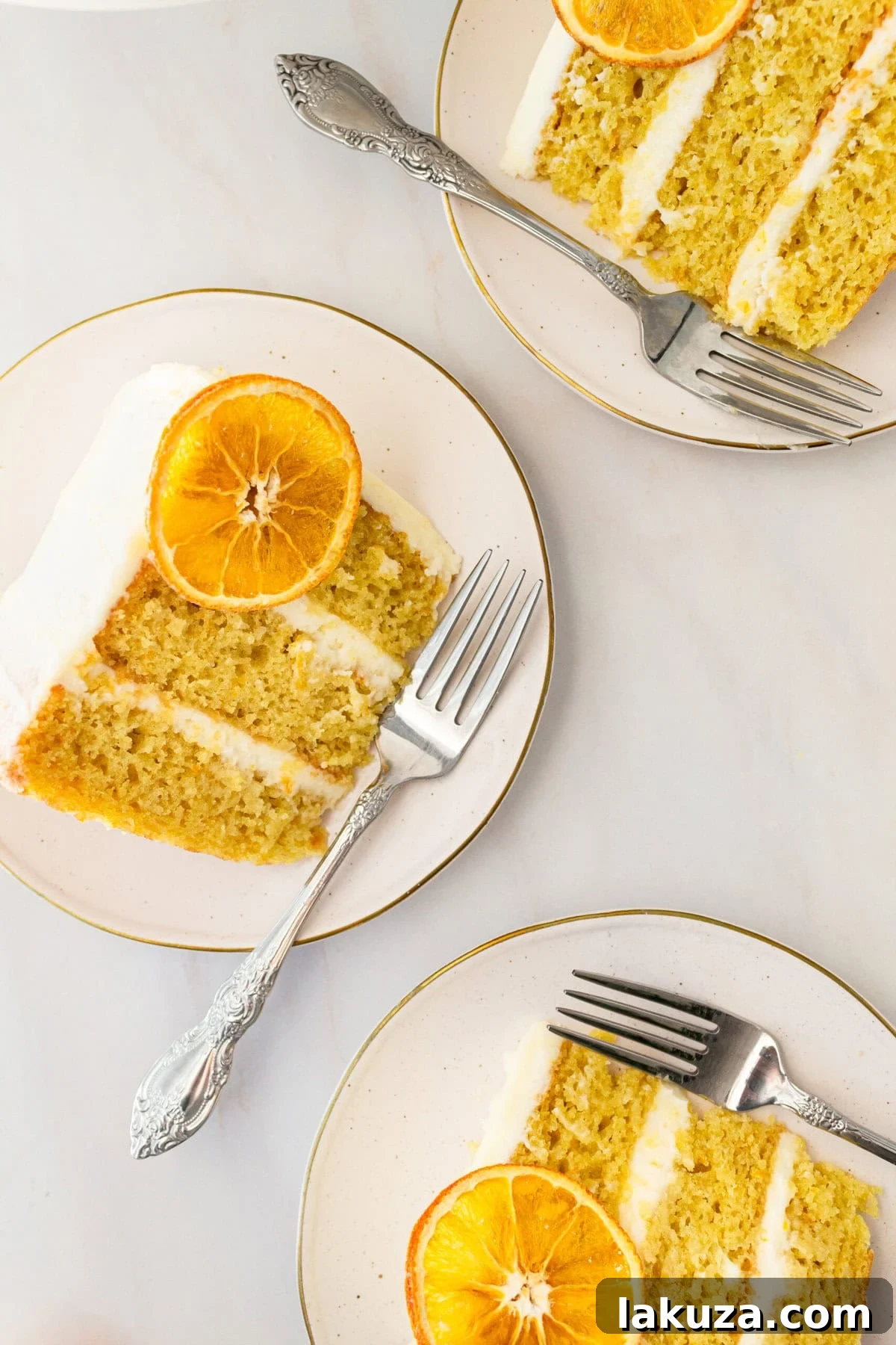 Zesty Orange Dream Cake 14 A beautifully presented slice of moist, tender fresh orange cake with sweet orange cream cheese frosting on a white plate. This homemade orange cake is famous for its bright citrus flavor in every fluffy bite, enhanced by expert baking tips. Perfect as a fully frosted or naked orange cake.