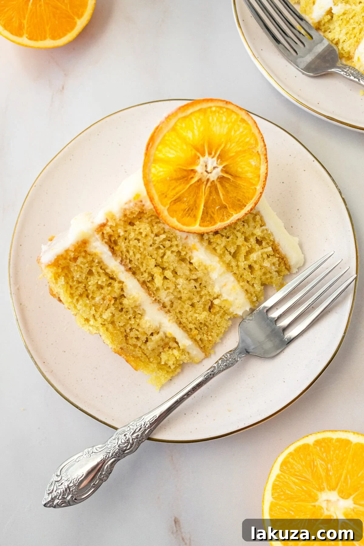 Zesty Orange Dream Cake 3 A multi-layered moist orange cake, generously frosted with a sweet orange cream cheese frosting, ready to be served. This homemade orange cake with fresh orange juice and zest offers a bright citrus flavor. Expert tips for making the perfect frosted or orange naked cake are provided.