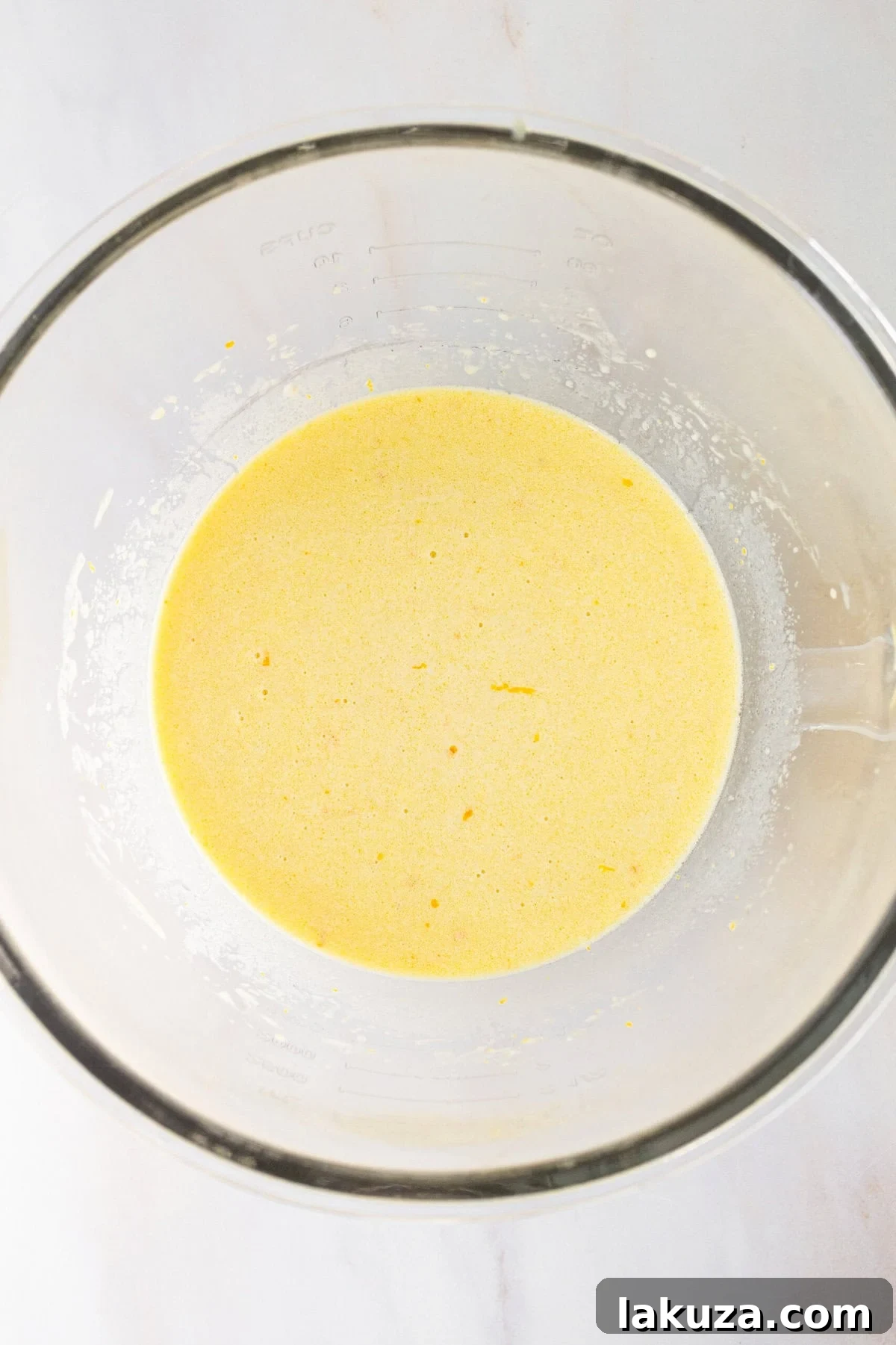 Zesty Orange Dream Cake 6 Close-up of vibrant orange cake batter, rich with fresh orange juice and finely grated orange zest, mixed in a bowl.