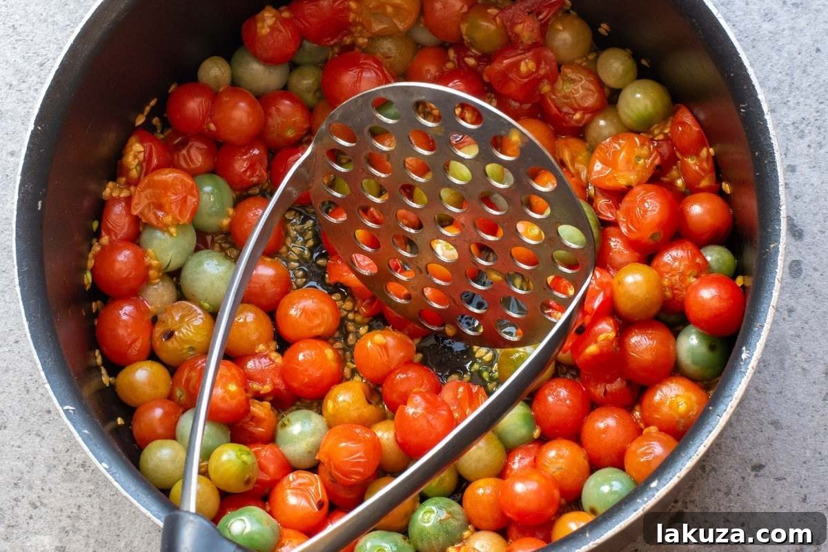 Sweet & Savory Tomato Jam 4 Whole tomatoes in pot with a masher.