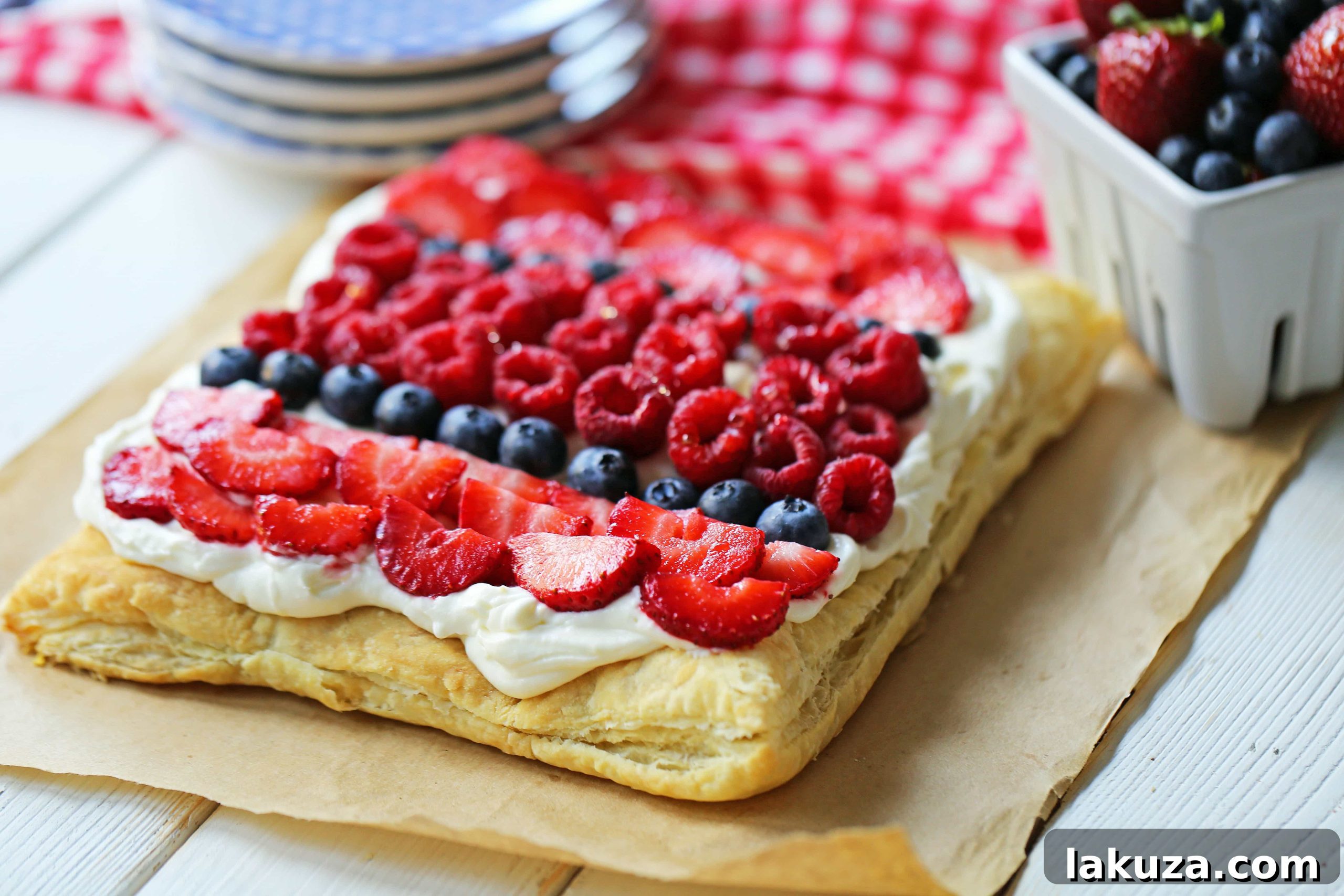 Overhead shot of a Lemon Berry Cheesecake Puff Pastry, beautifully arranged with a variety of fresh berries like strawberries, blueberries, and raspberries, showcasing the golden pastry.