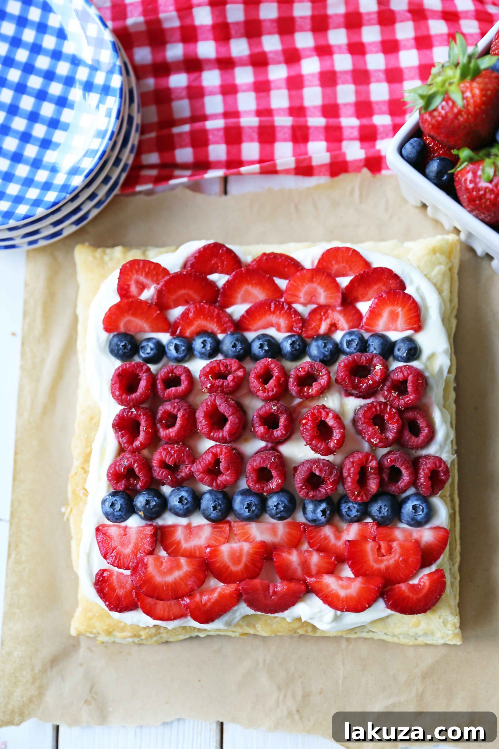 Close-up of a slice of Lemon Berry Cheesecake Puff Pastry, revealing the delicate layers of baked puff pastry, thick lemon cheesecake, and juicy berries.