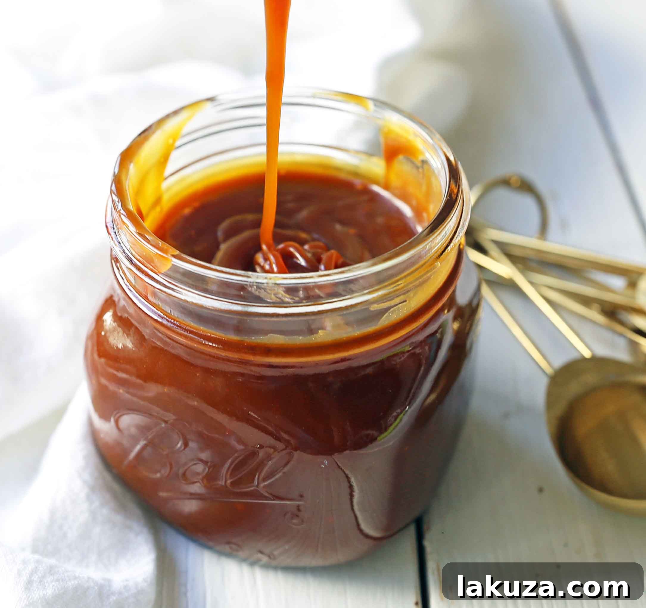 Rich, golden homemade salted caramel sauce in a glass jar, ready to be enjoyed as a luxurious dessert topping.