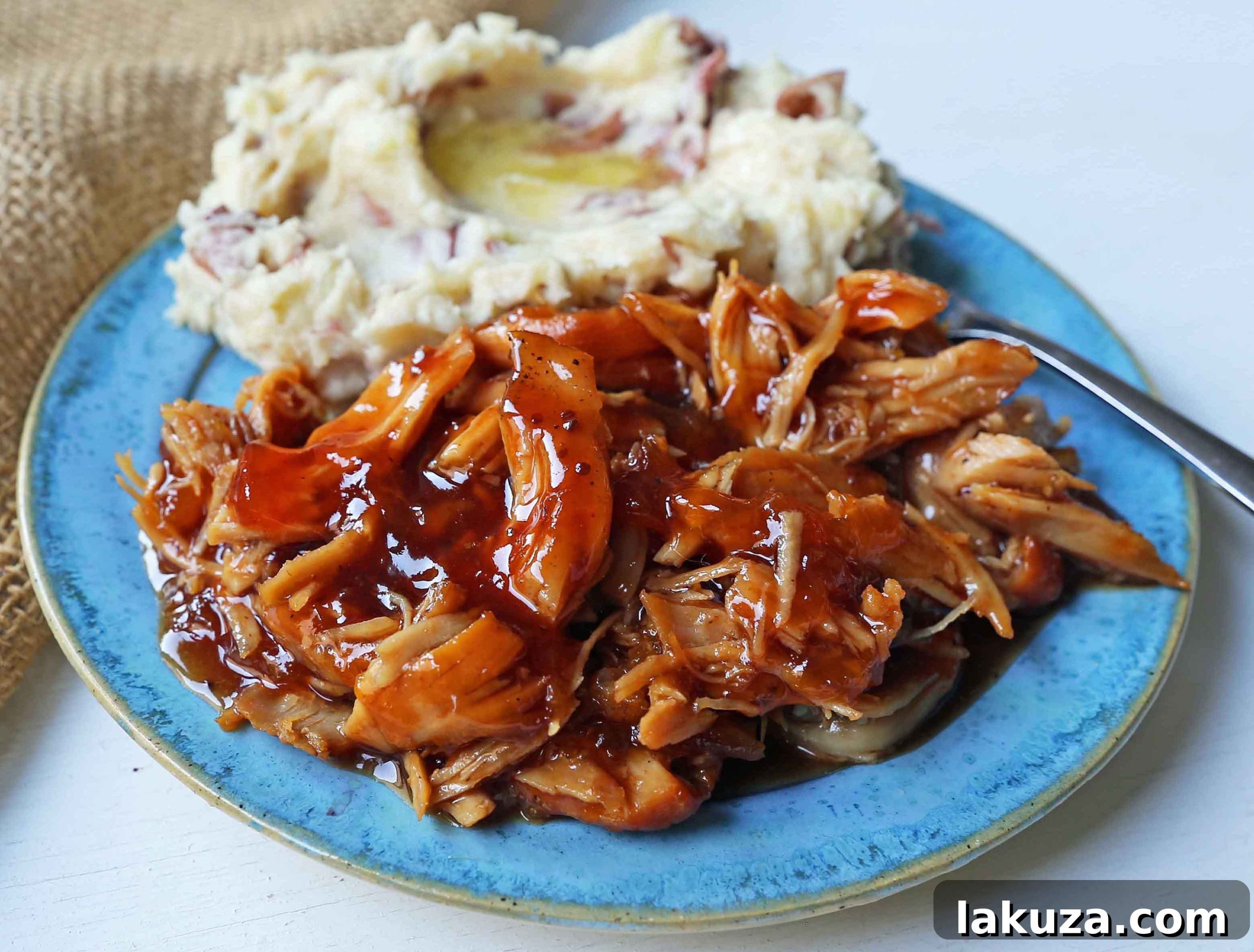 Close-up of Slow Cooker Peach Barbecue Sauce Chicken, showcasing the tender texture and rich glaze. Easy 5-ingredient crockpot recipe for a sweet and savory meal.
