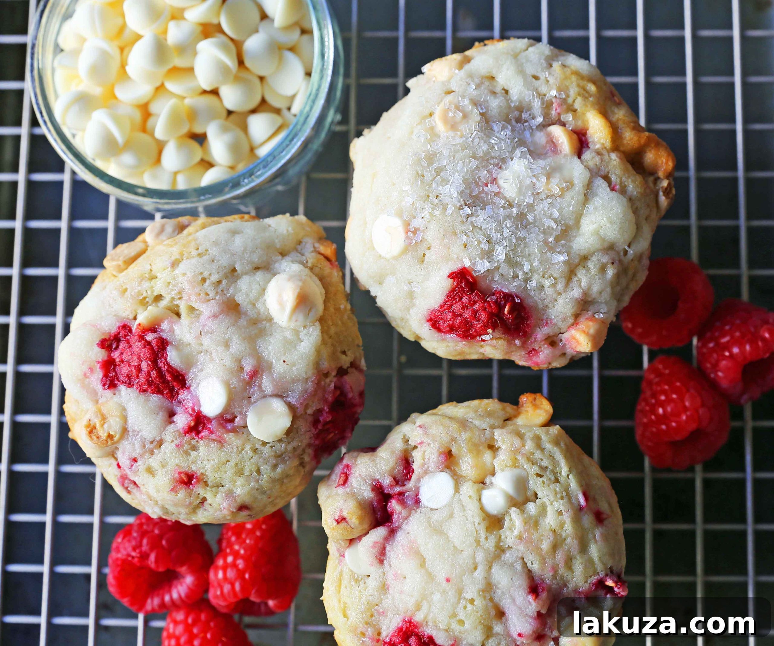 Decadent Raspberry White Chocolate Muffins 5 A tray of freshly baked Raspberry White Chocolate Muffins cooling on a wire rack, with their golden-brown tops and sparkling sugar visible.