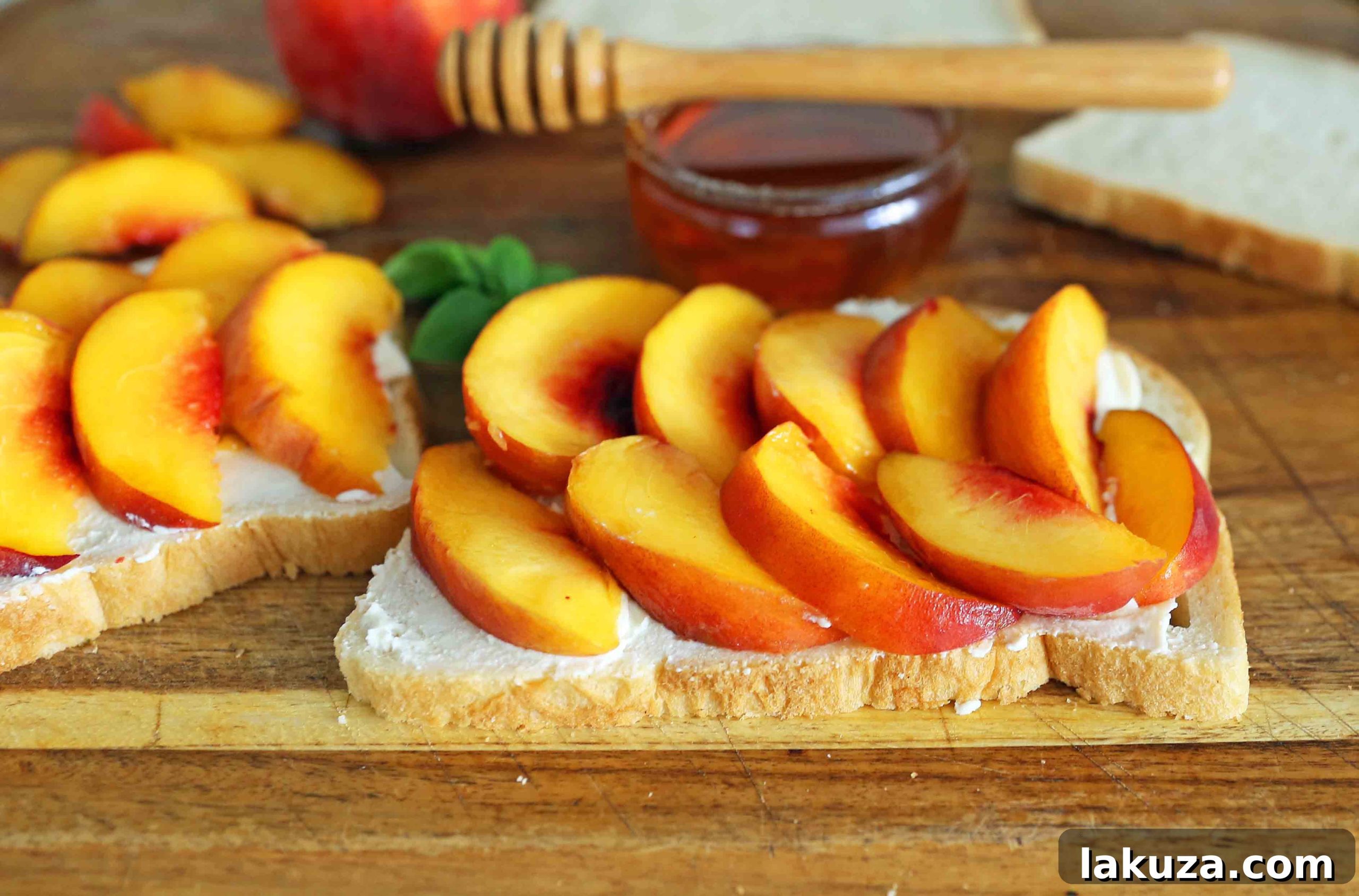 Close-up view of a half-eaten Honey Peach White Cheddar Grilled Cheese sandwich, showcasing the gooey melted cheese and vibrant peach slices inside the crispy bread.