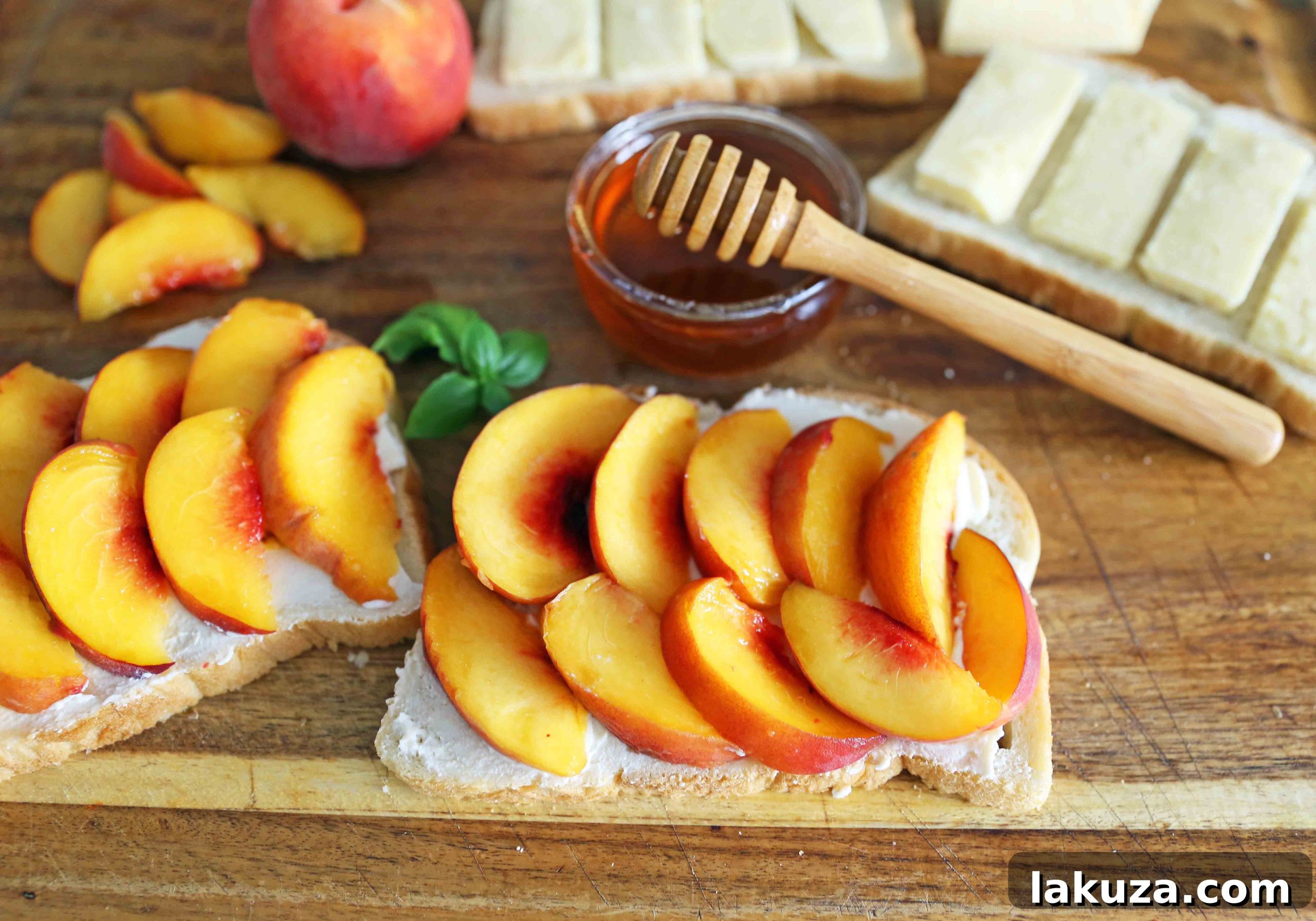 A stack of two freshly made Honey Peach White Cheddar Grilled Cheese sandwiches, cut diagonally, on a wooden board, ready to be enjoyed as a summer delight.