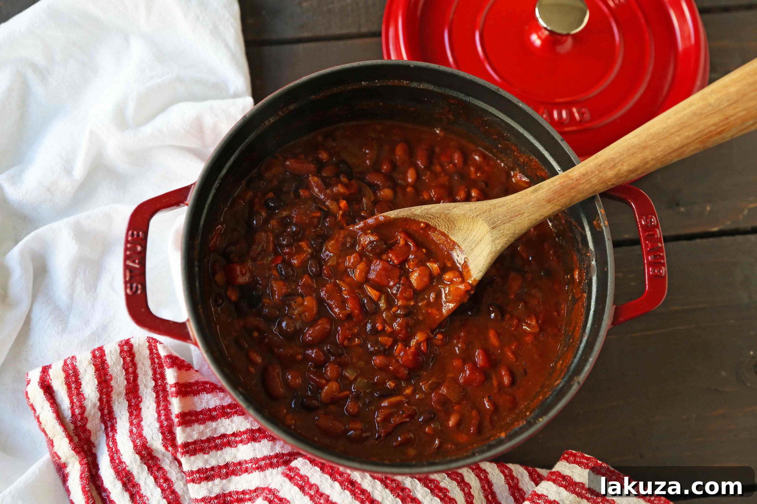 Delicious Vegetarian Chili: A close-up of a steaming bowl of homemade veggie chili, featuring kidney beans, pinto beans, black beans, bell peppers, carrots, and onions in a rich, seasoned tomato base. A perfect plant-based meal.