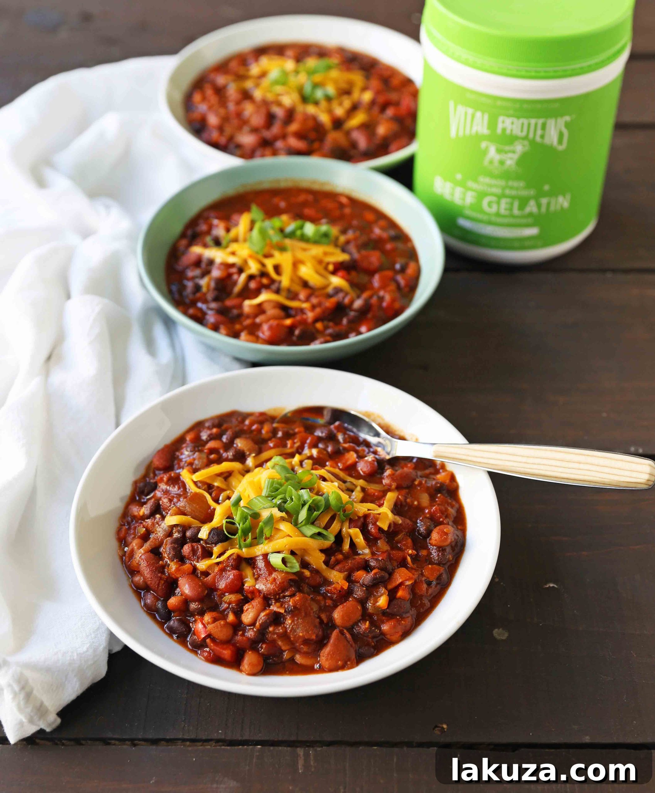 Colorful and Healthy Veggie Chili: A vibrant bowl of vegetarian chili, showcasing a variety of finely diced bell peppers (red, orange, yellow), carrots, and onions, alongside mixed beans in a rich tomato sauce. Ideal for a healthy, meatless meal.