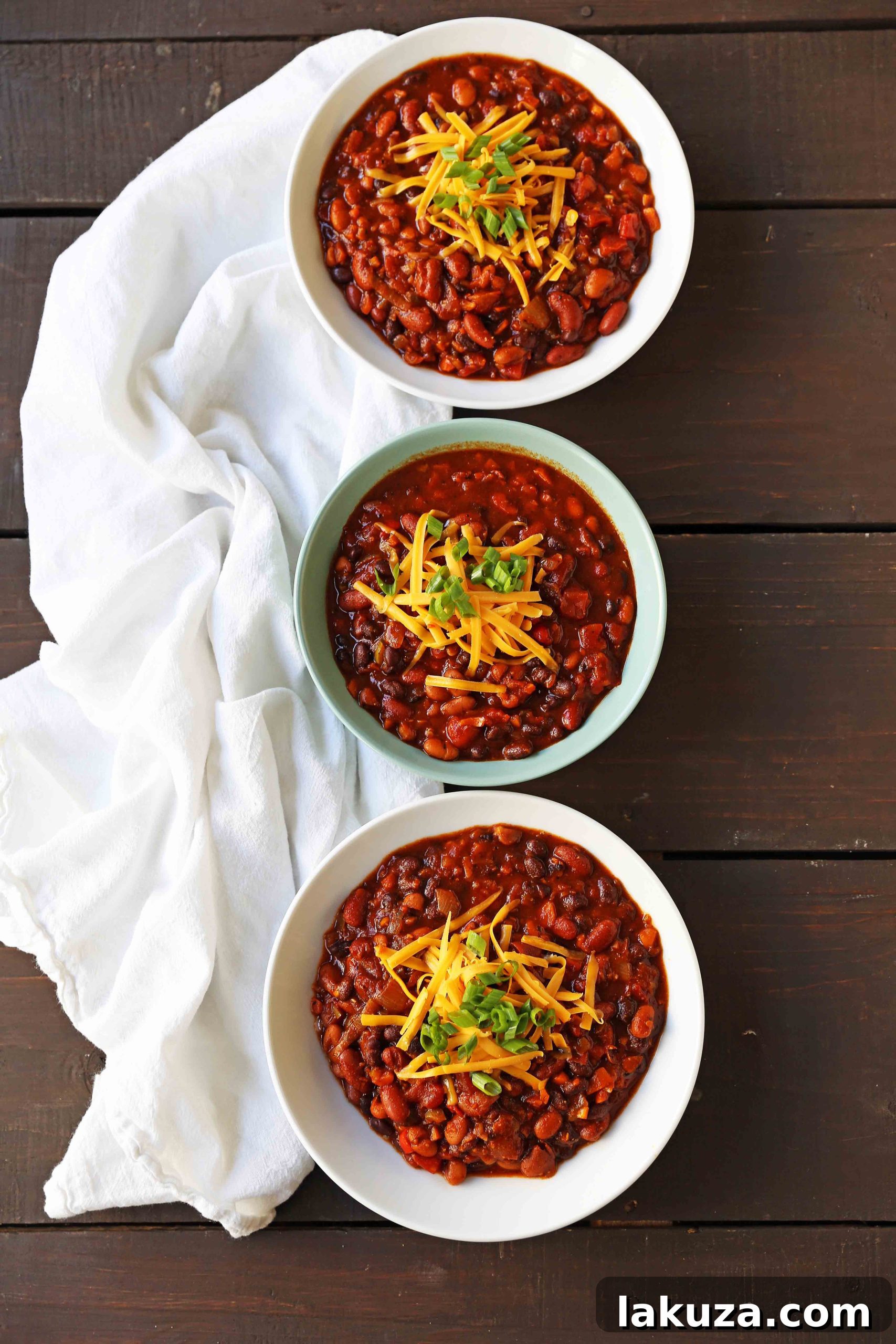 Cooking Veggie Chili: A close-up of colorful, finely diced vegetables – red, orange, yellow bell peppers, onions, and carrots – sautéing in a large pot with olive oil, ready for the next steps of a delicious vegetarian chili recipe.