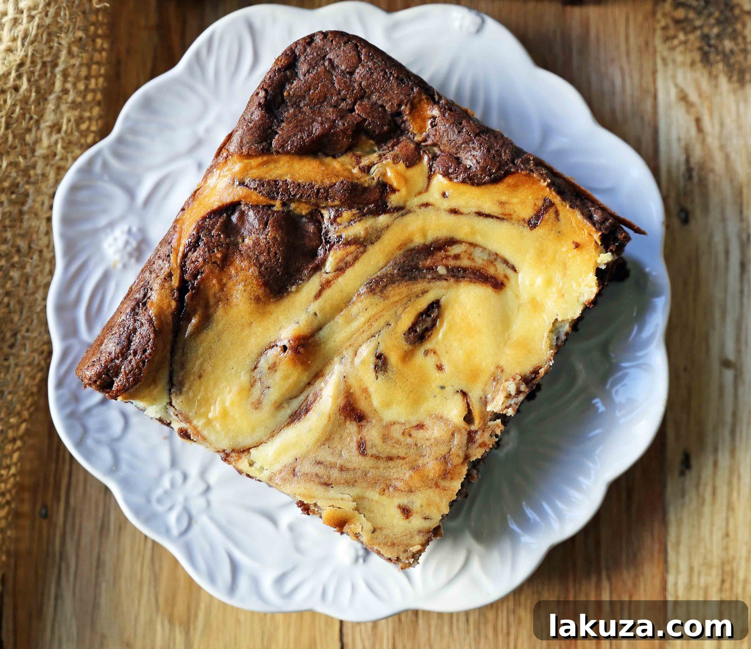 Decadent Cheesecake Brownies 3 Close-up shot of baked cheesecake brownies, showcasing the intricate cream cheese swirl against the dark chocolate brownie base.