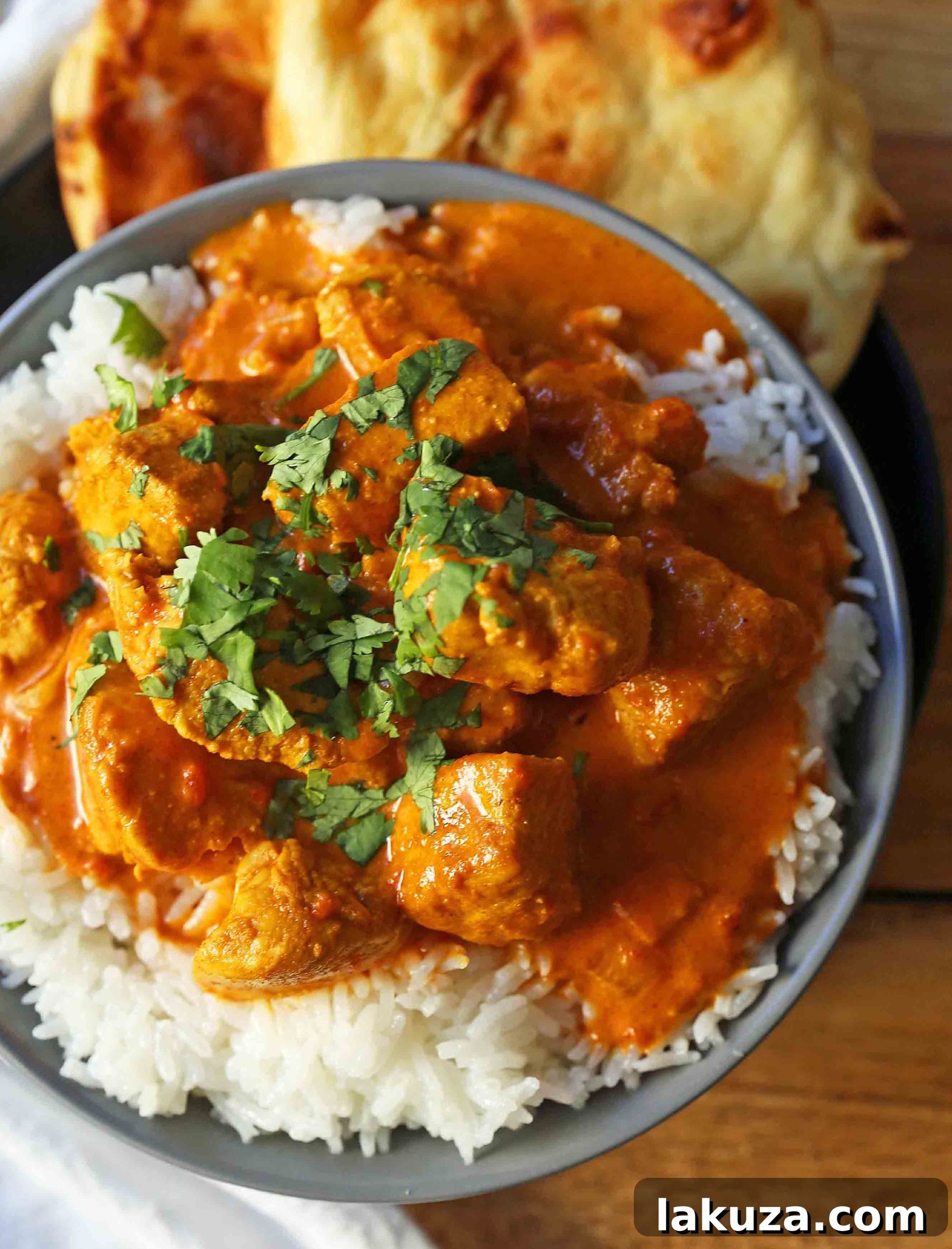A bowl of creamy Chicken Tikka Masala garnished with fresh cilantro, ready to be served.
