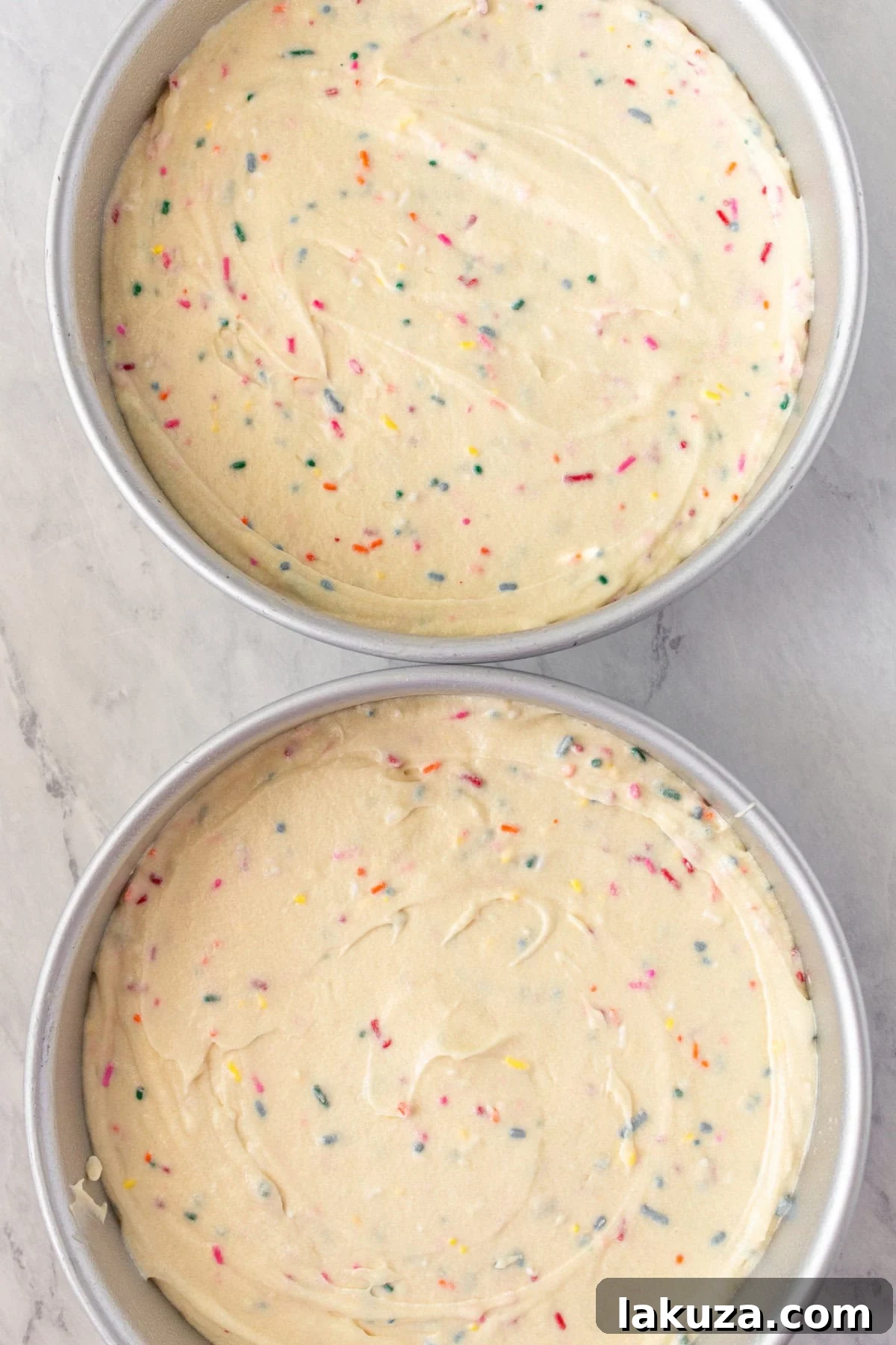 Joyful Sprinkle Celebration 10 Smooth, sprinkle-laden Funfetti cake batter evenly distributed across multiple round cake pans, ready for baking in the oven.