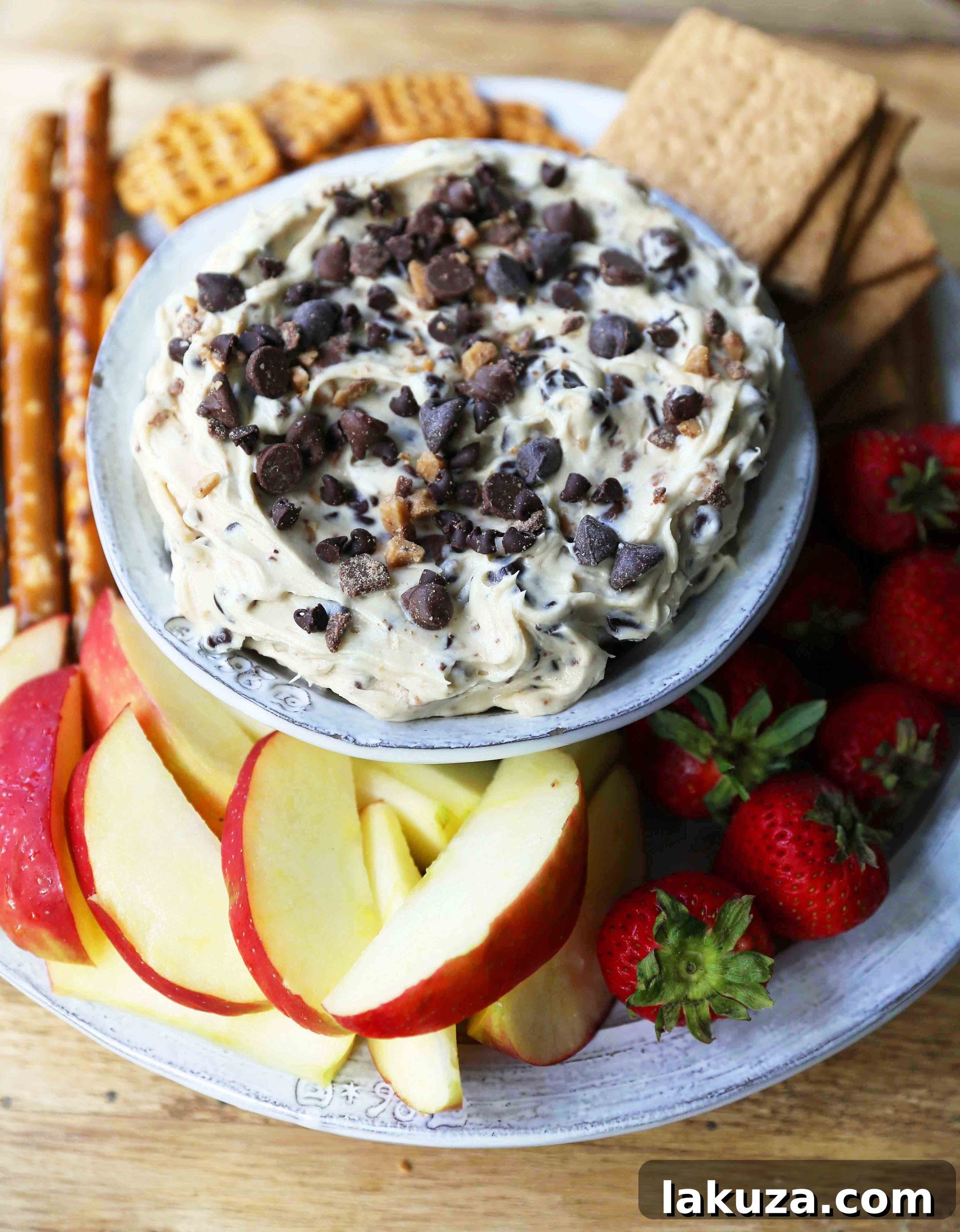 Close-up of creamy Chocolate Chip Cookie Dough Dip, showcasing the abundance of chocolate chips and crunchy toffee bits, ready to be scooped with your favorite dippers.