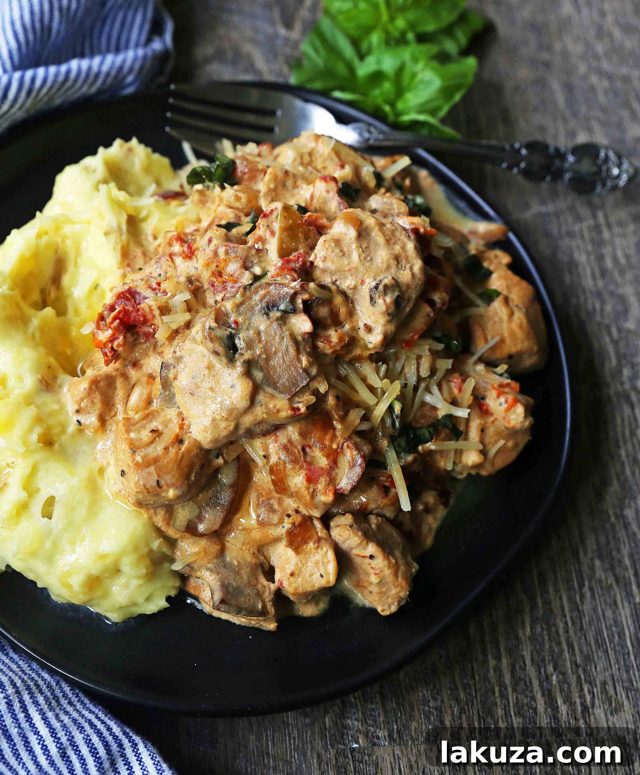 Close-up of Slow Cooker Creamy Tuscan Chicken. Creamy tender chicken in prosciutto, mushroom, and sundried tomato cream sauce. Comfort food made in a slow cooker.