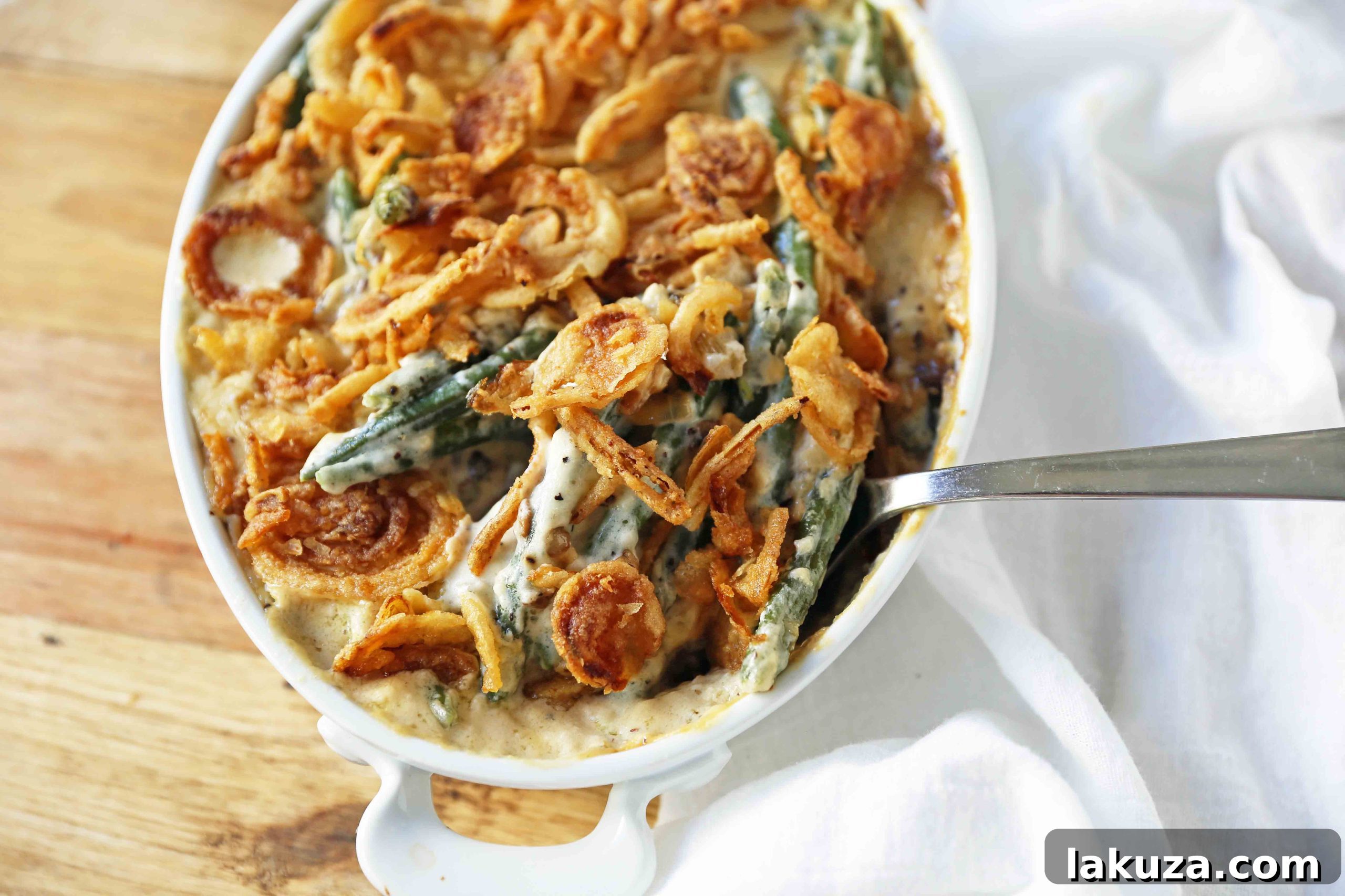 Freshly prepared Green Bean Casserole in a baking dish, ready for the oven, showcasing tender green beans and a rich sauce.