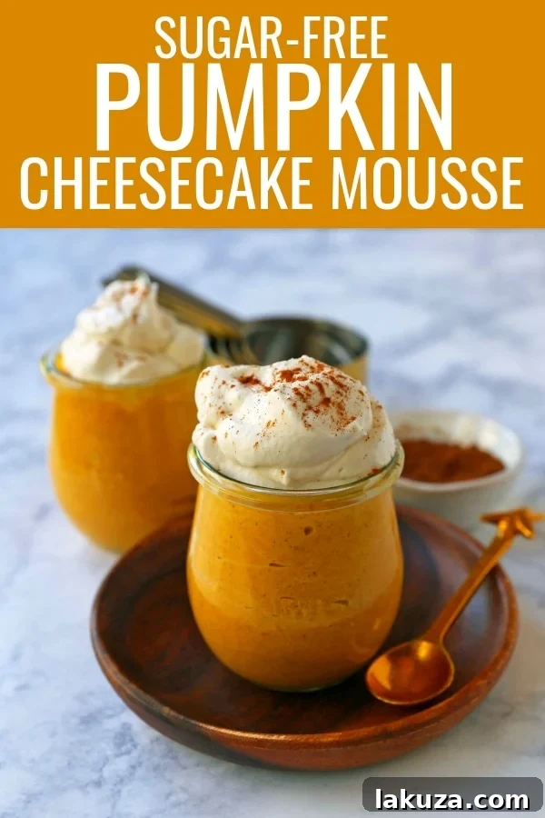 Close-up of a spoon digging into a serving of sugar-free pumpkin cheesecake mousse, showing its fluffy and creamy texture with whipped cream topping.