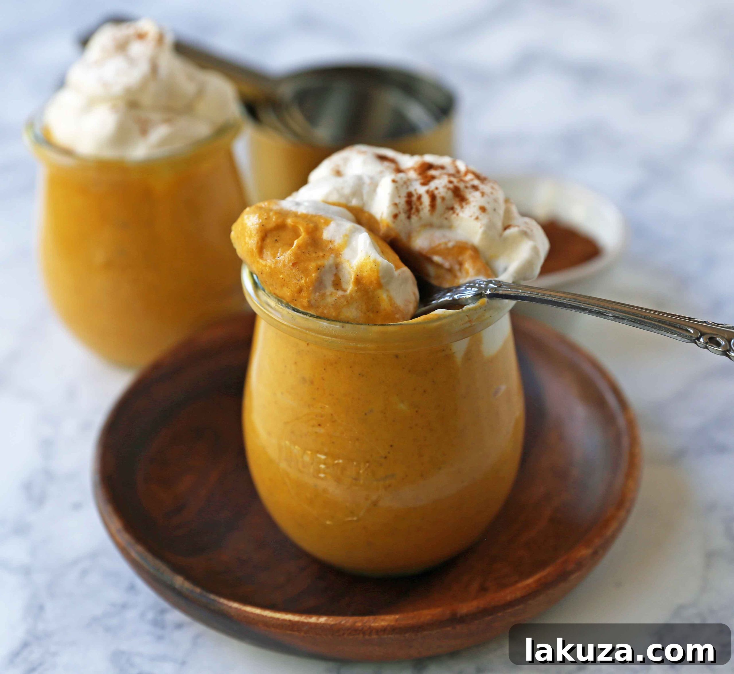 A bowl of creamy pumpkin cheesecake mousse being prepared, showing its smooth, light orange texture before chilling. Ideal for a quick and easy no-bake dessert.