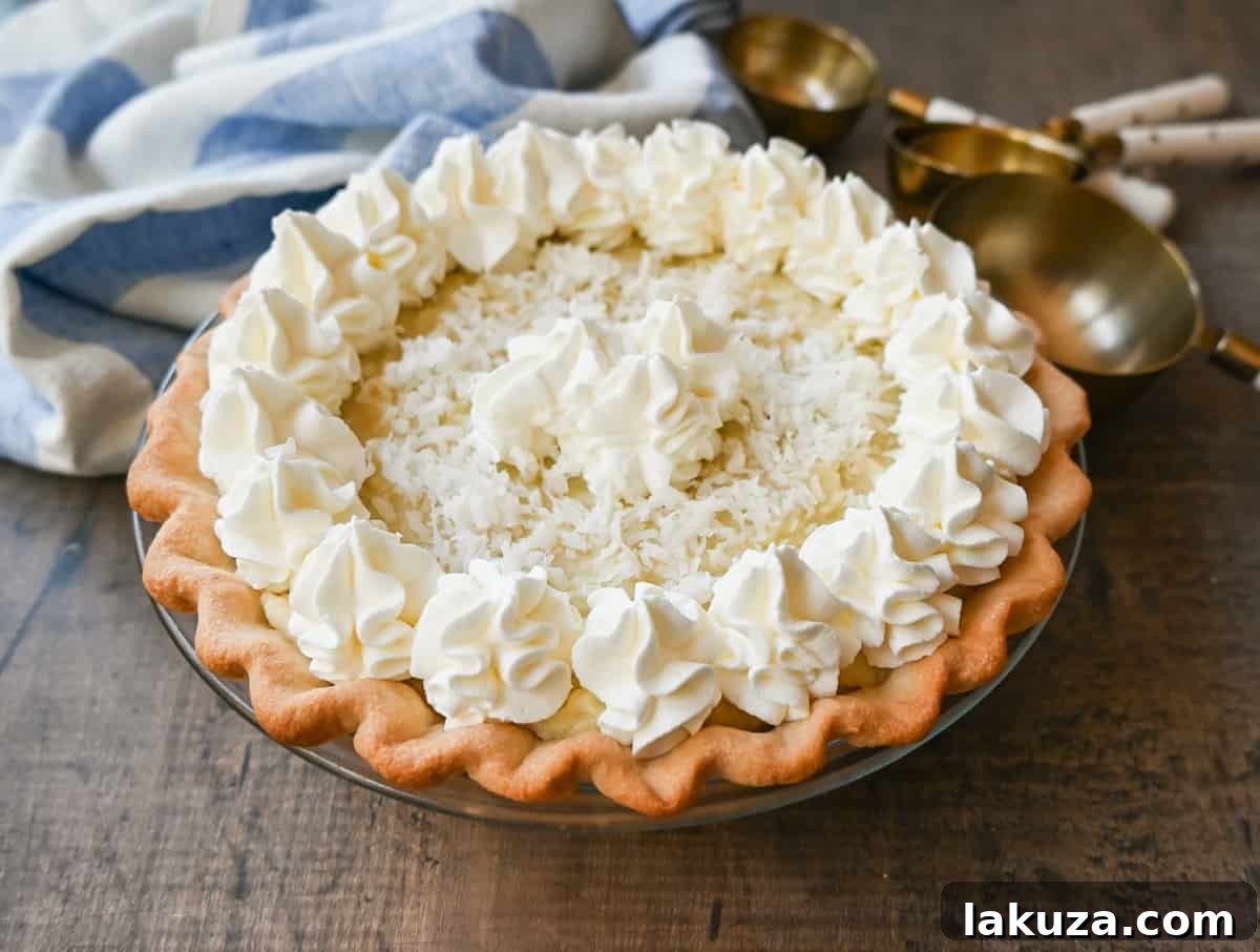 Close-up of a Coconut Cream Pie showing the creamy filling and toasted coconut topping, ready to be served.