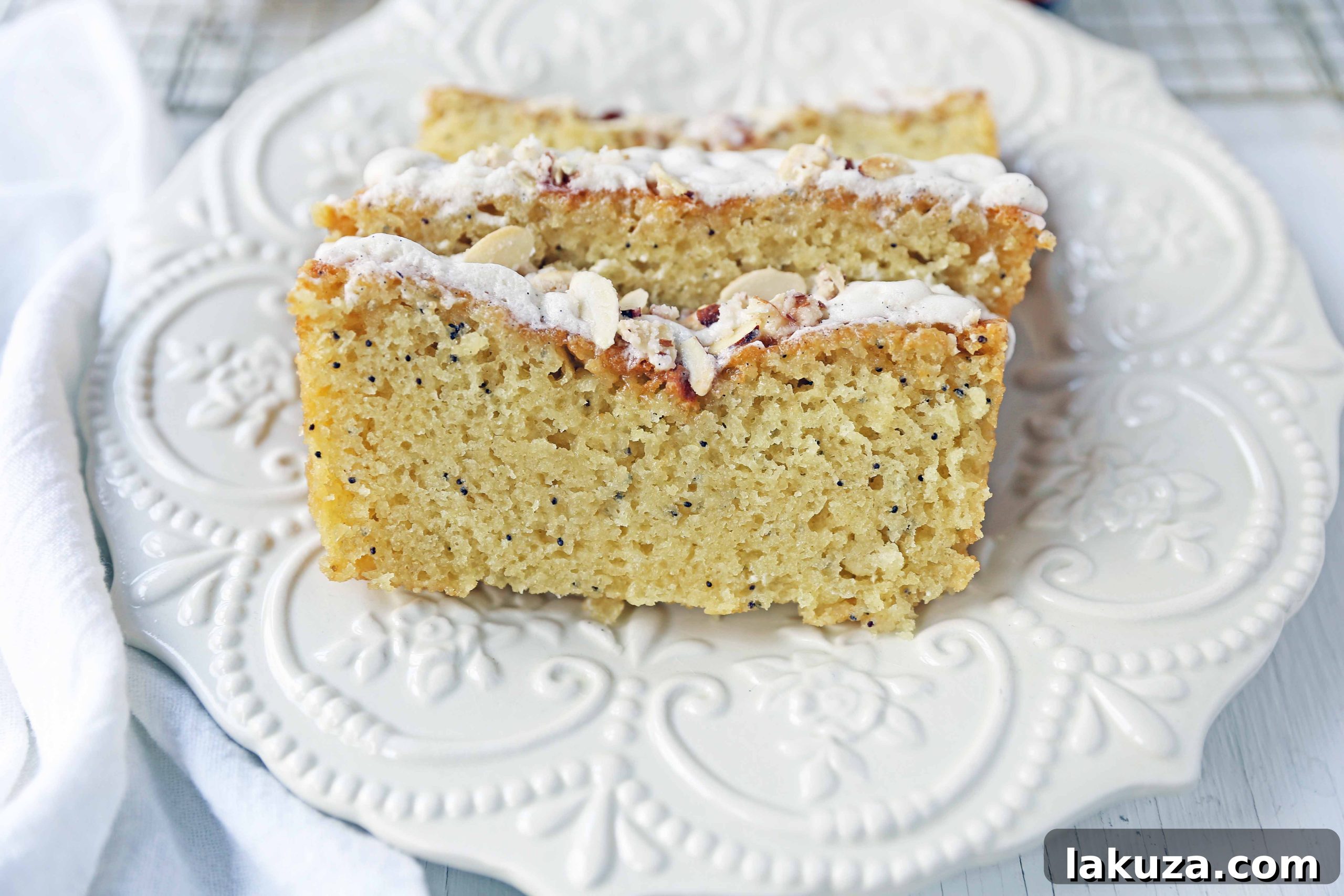 Almond Poppy Seed Bread loaf drizzled with glaze and topped with candied almonds