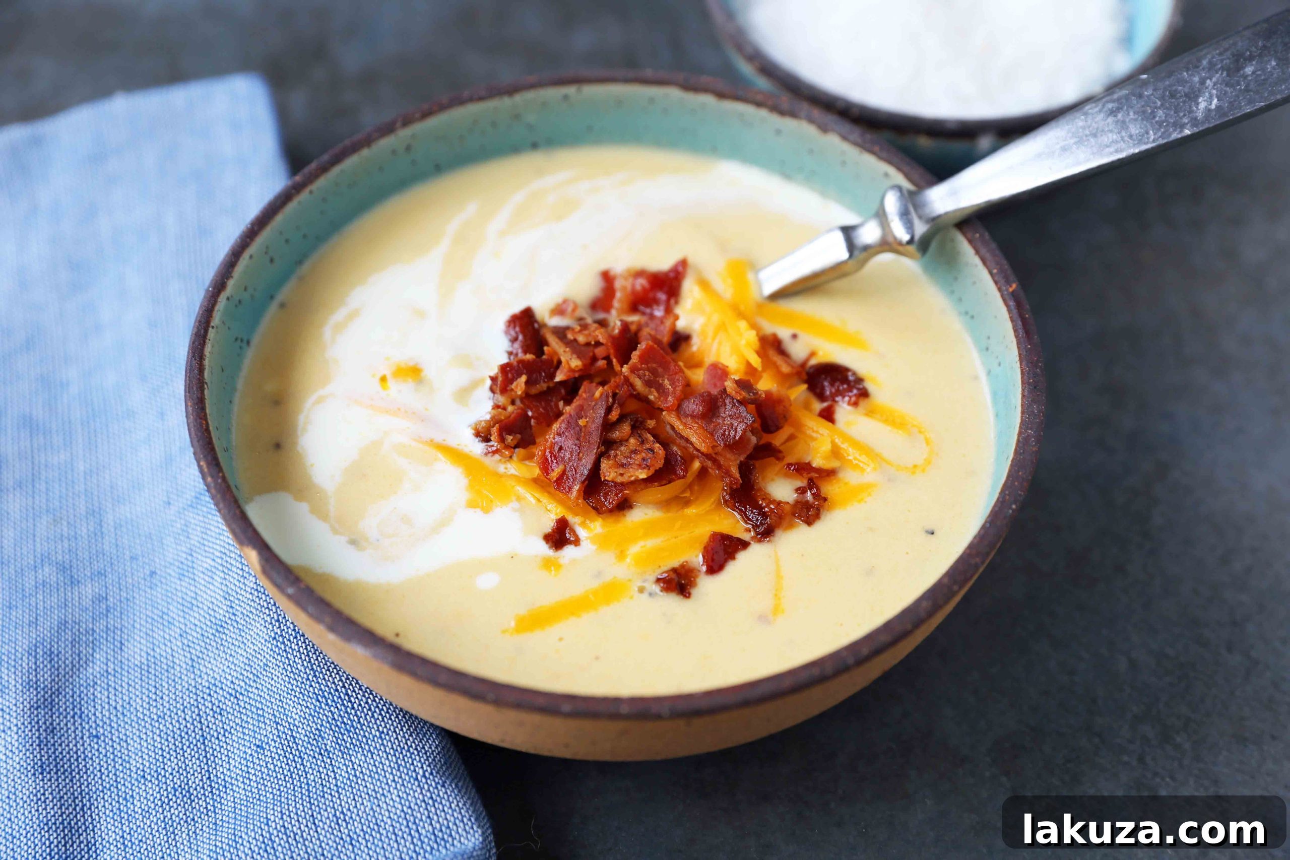 Rich and Creamy Cauliflower Cheese Soup 5 Ingredients for cheesy cauliflower soup laid out: chopped cauliflower, cheddar cheese, cream, and bacon.
