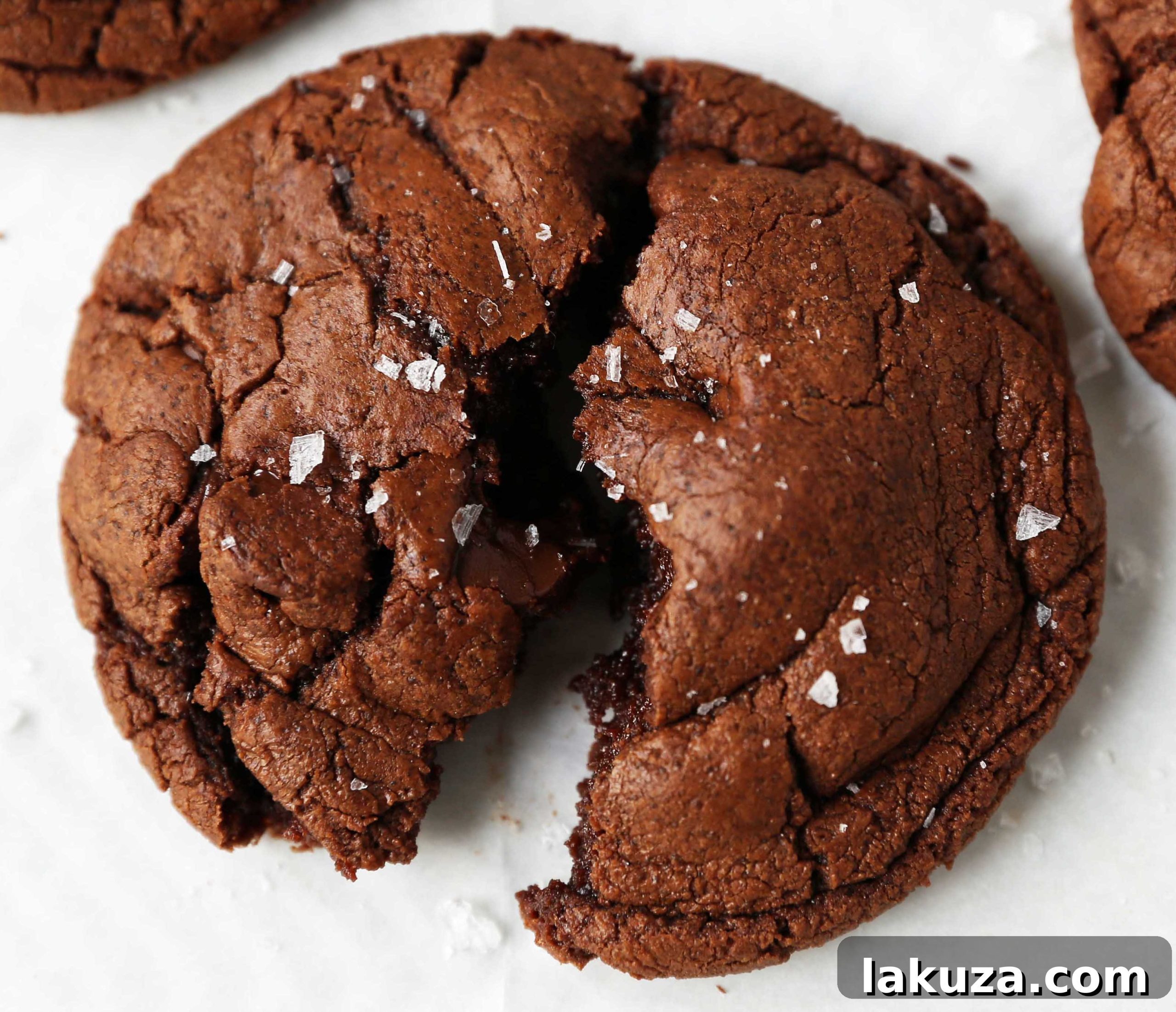 Decadent Chocolate Brownie Cookies 5 A baking sheet filled with freshly scooped chocolate brownie cookie dough, ready for the oven, on parchment paper.