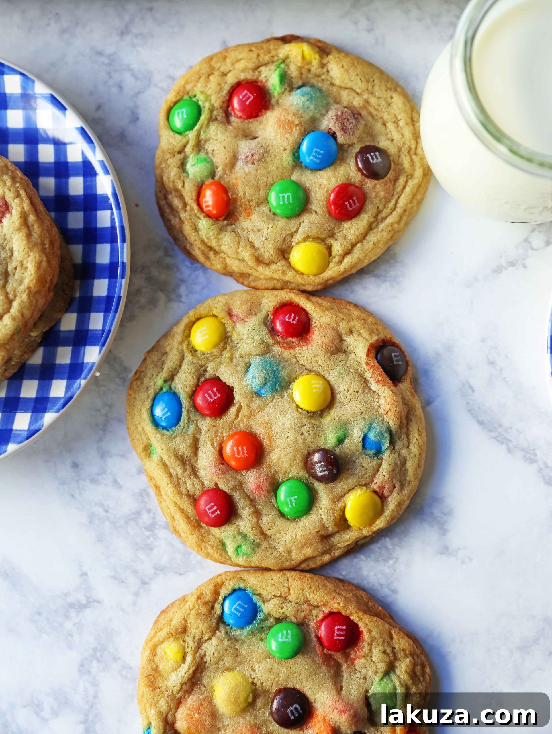 Soft and Chewy M&M Cookies: Hands preparing cookie dough balls with M&M candies before baking.