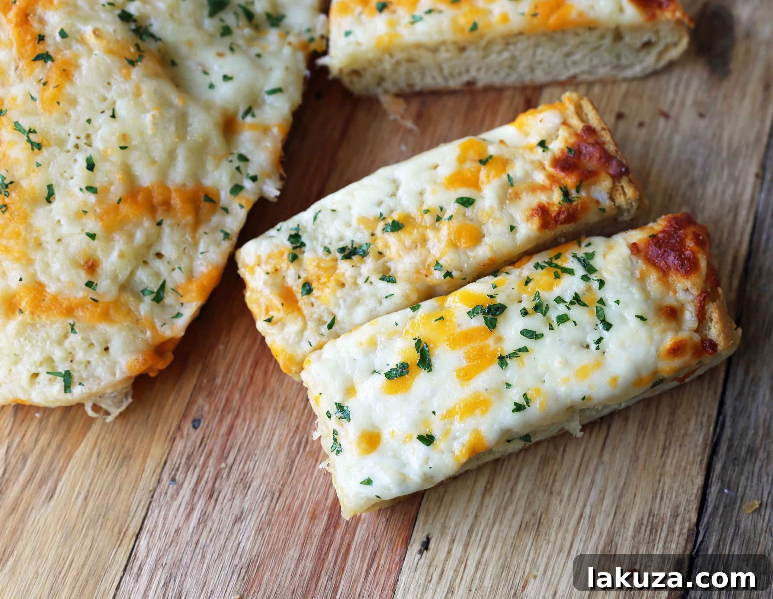 Irresistible Garlic Cheese Bread 6 Finished garlic cheese bread on a wooden board, with several slices already cut and ready to be enjoyed, highlighting the perfect golden crust and melted cheese.