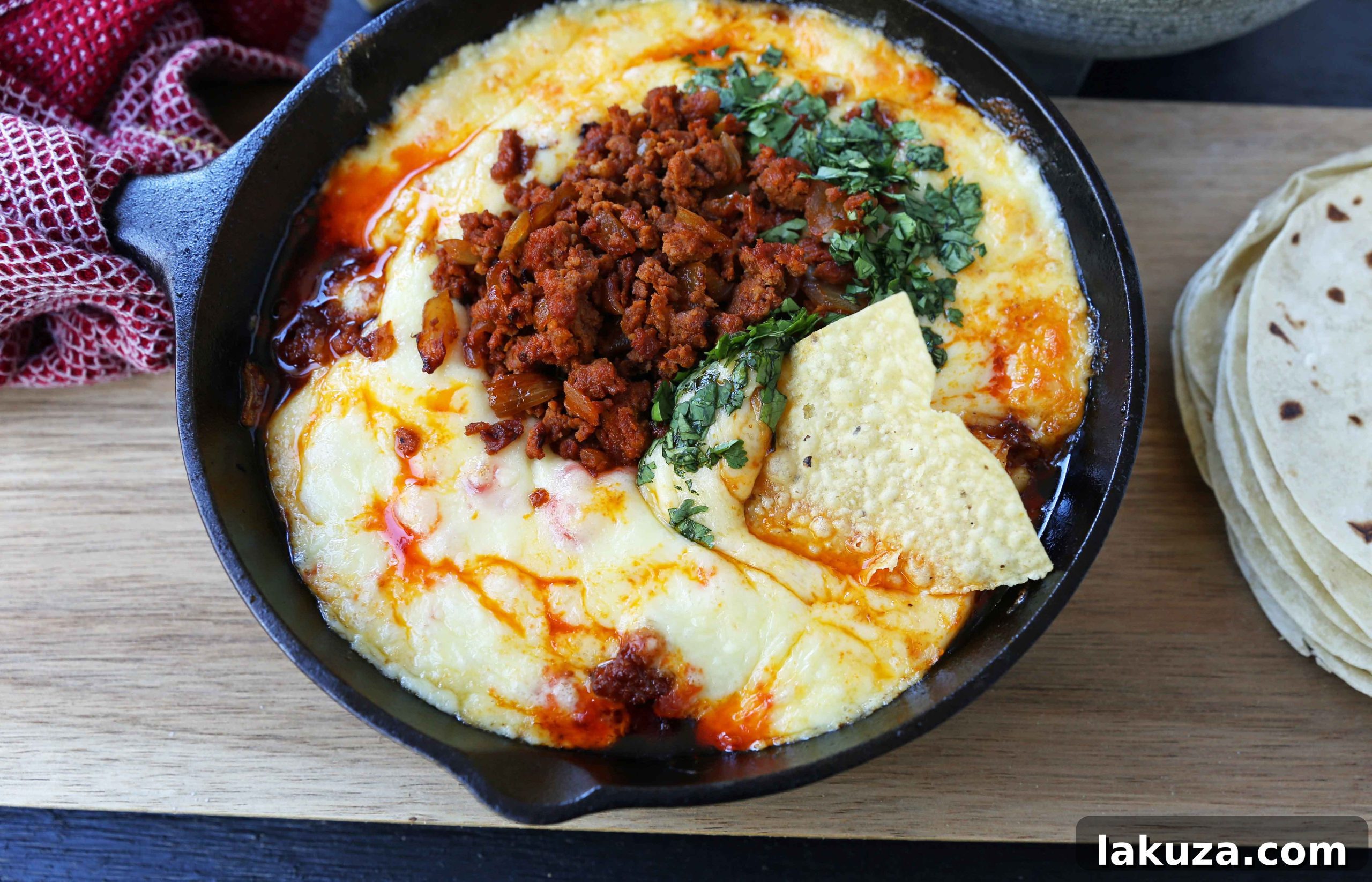 Queso Fundido with Chorizo. A skillet of melted Mexican cheeses seasoned with peppers, onions, and spicy Mexican chorizo sausage and served with hot tortillas or chips. The perfect Mexican appetizer!