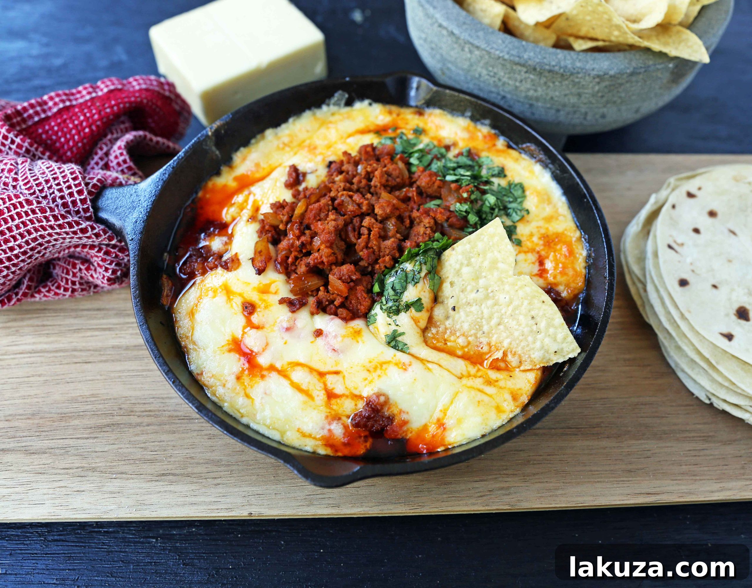 Queso Fundido with Chorizo. A skillet of melted Mexican cheeses seasoned with peppers, onions, and spicy Mexican chorizo sausage and served with hot tortillas or chips. The perfect Mexican appetizer!