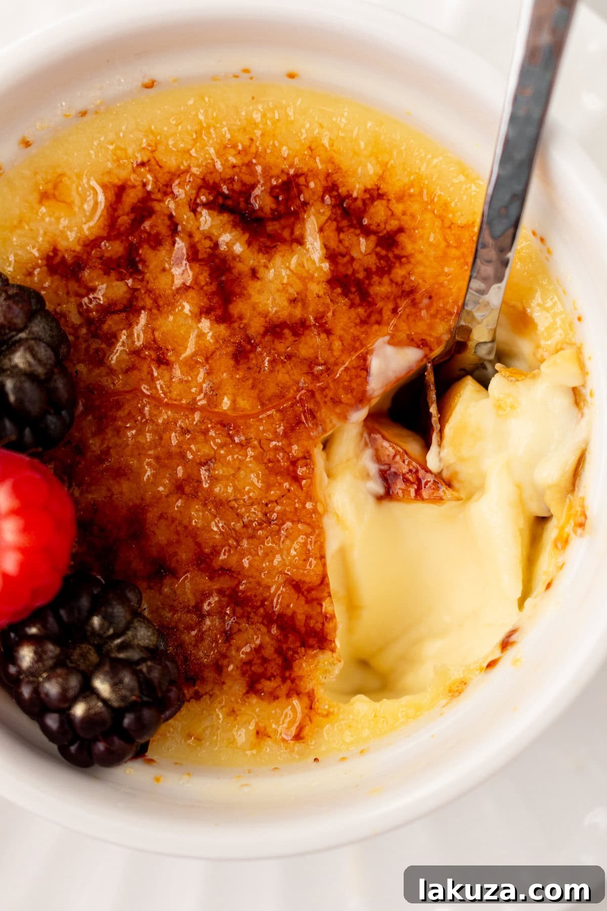 A spoon dishing out creme brulee. A creamy, silky vanilla custard topped with crisp sugar crust is one of the most popular desserts at restaurants for good reason. With its silky custard base and crackly caramelized sugar topping, it’s a showstopper that’s surprisingly easy to make at home. 