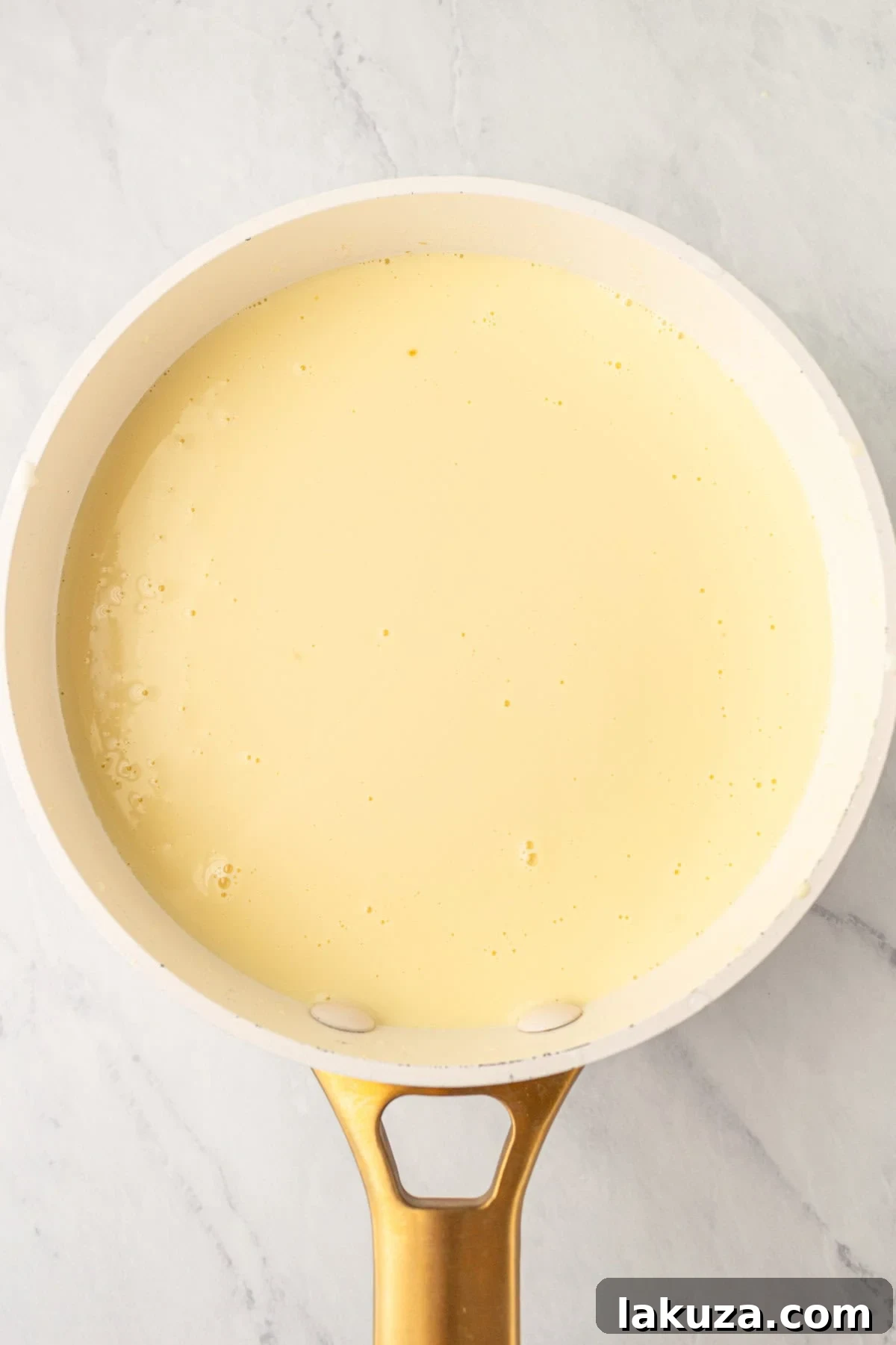 Tempering egg yolks and adding them to heavy cream and sugar mixture to make homemade creme brulee
