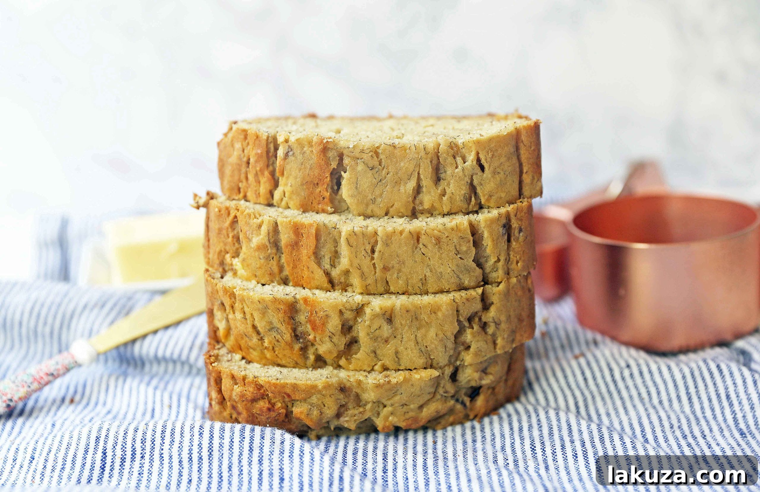 A beautiful loaf of banana bread, sliced and ready to serve, garnished with banana slices