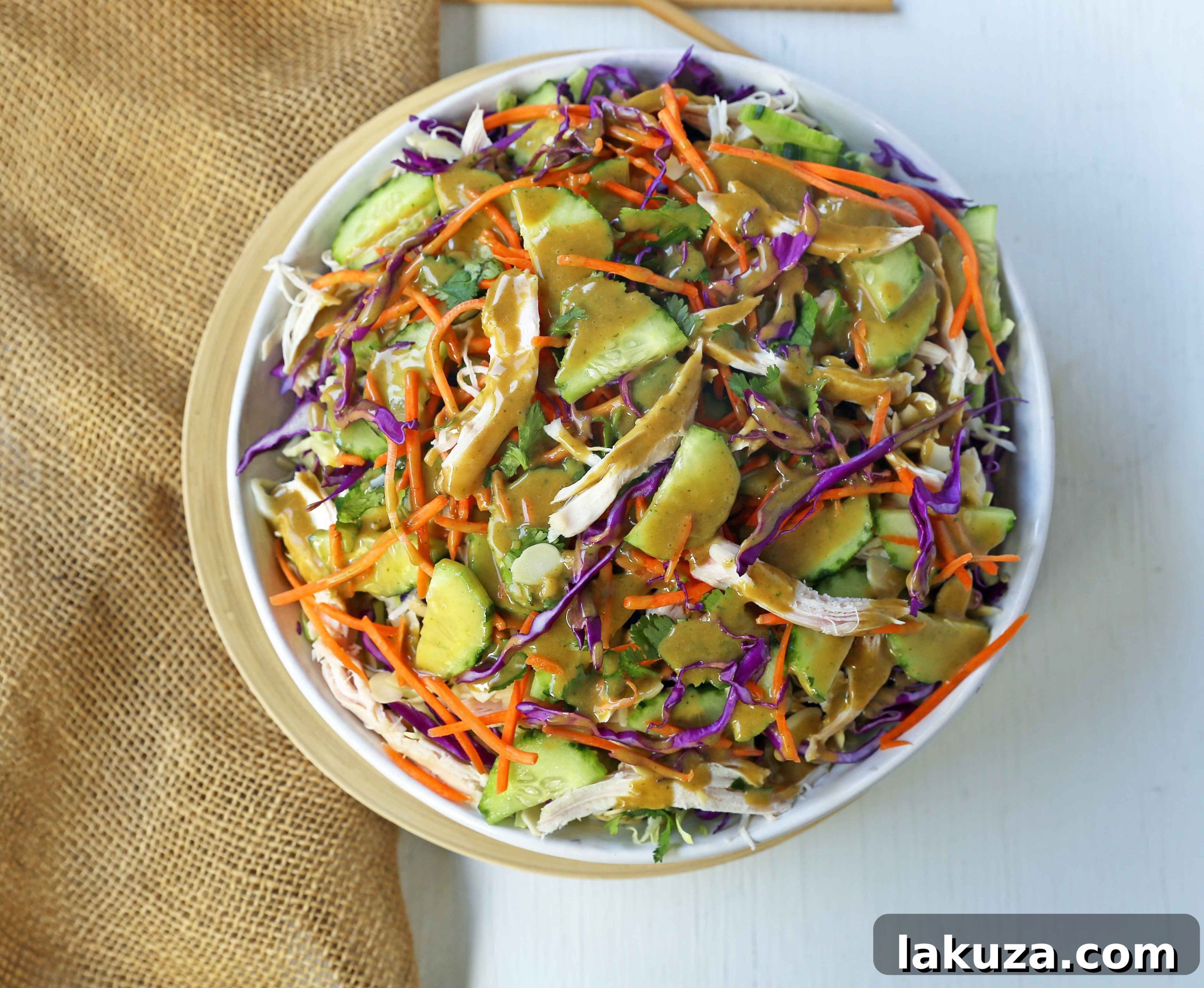 Close-up of fresh Thai Chicken Salad with shredded chicken and rich peanut dressing.