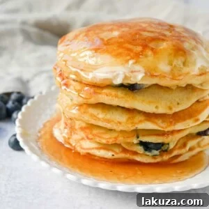Homemade fluffy blueberry pancakes are made with fresh blueberries and are the best buttermilk blueberry pancakes ever! These are easy blueberry pancakes made from scratch.