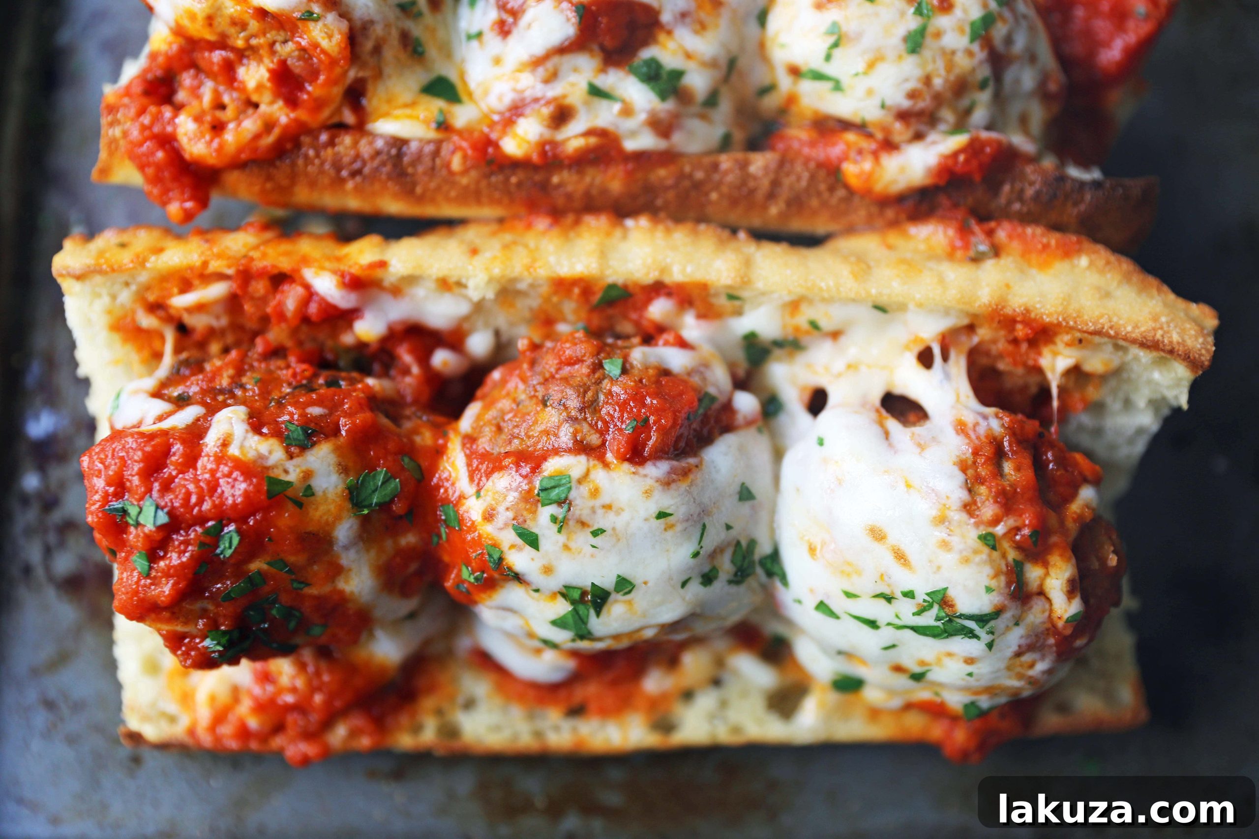 Close-up of juicy beef parmesan meatballs being prepared for the ultimate sub