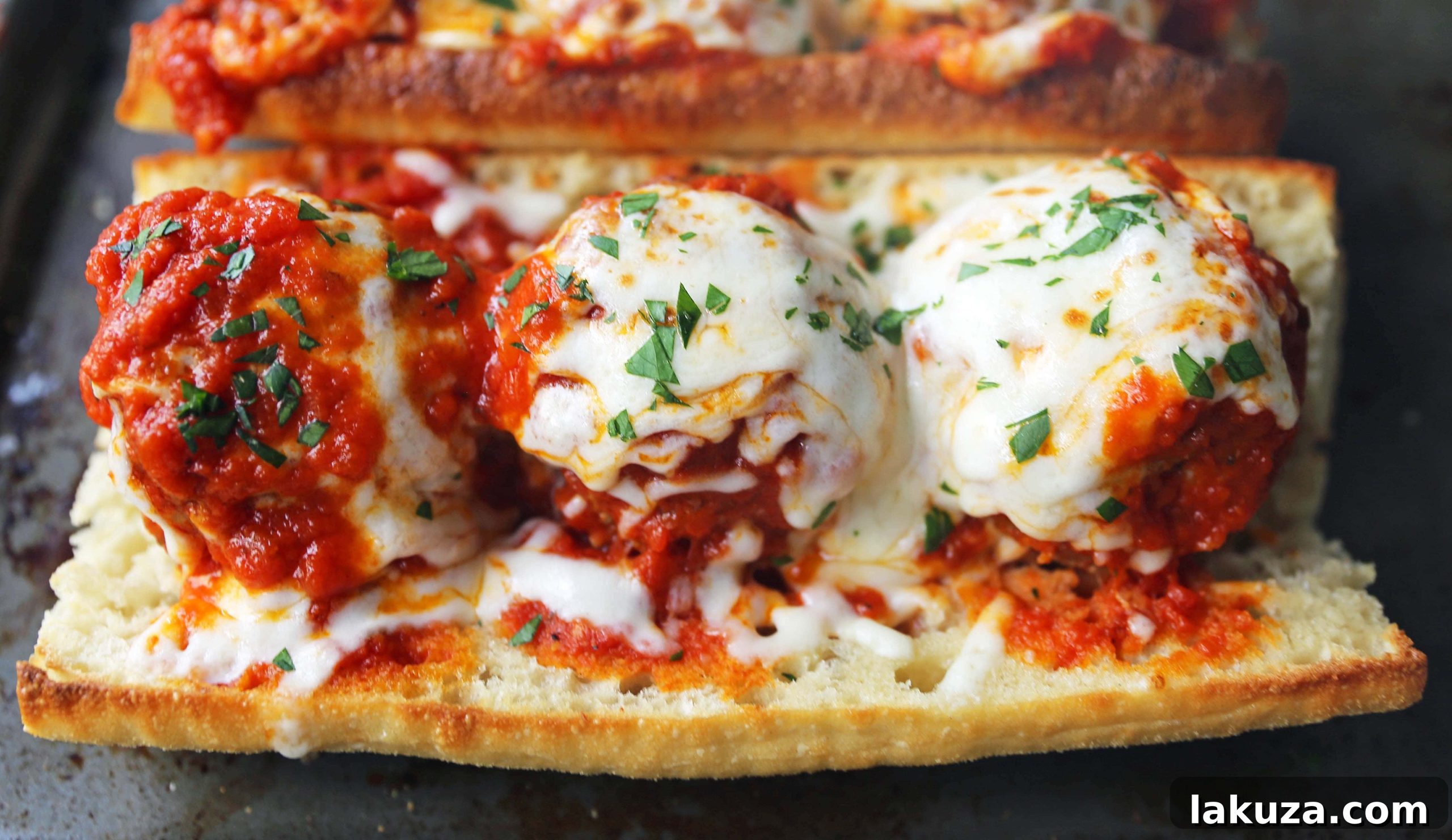 Assembly of Italian meatball subs with melted mozzarella cheese on toasted bread